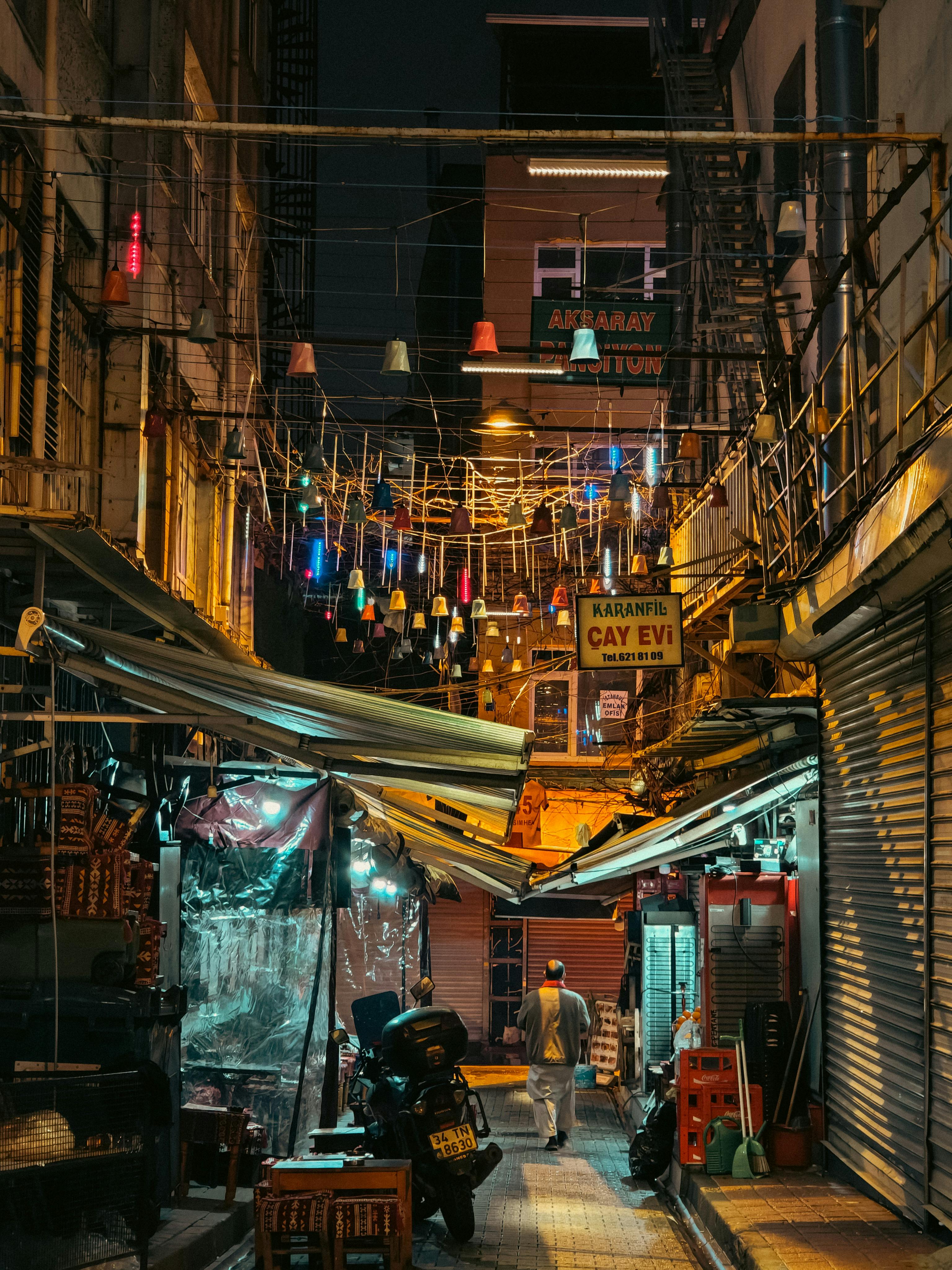 ฟรี ตรอกในเมืองที่คึกคักไปด้วยแสงไฟหลากสีและร้านค้าในยามค่ำคืน คลังภาพถ่าย