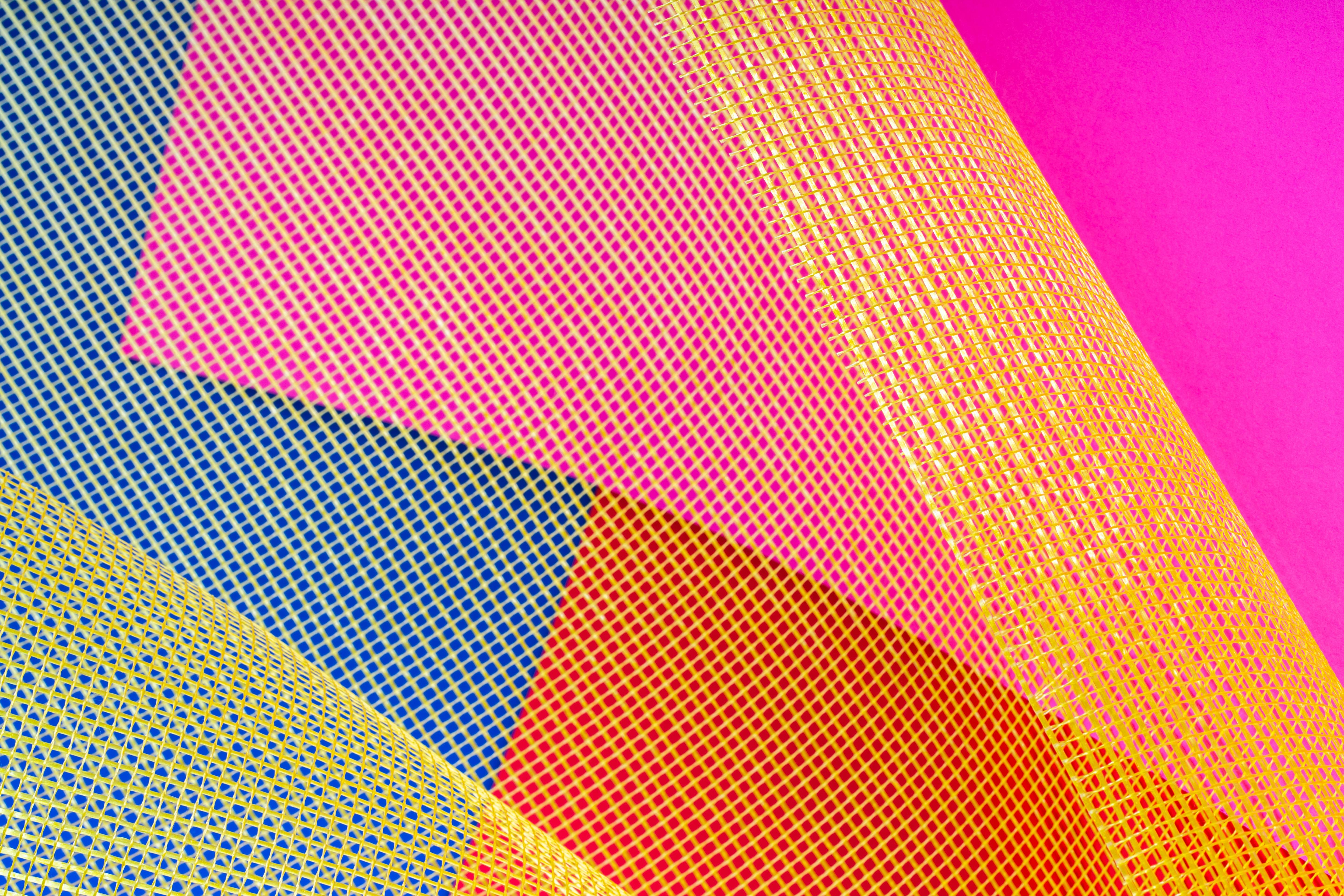 Zadarmo Abstraktný obrázok so žiarivými geometrickými vzormi a žltým sieťovaným prekrytím s ružovou, modrou a červenou farbou. Fotka z fotobanky