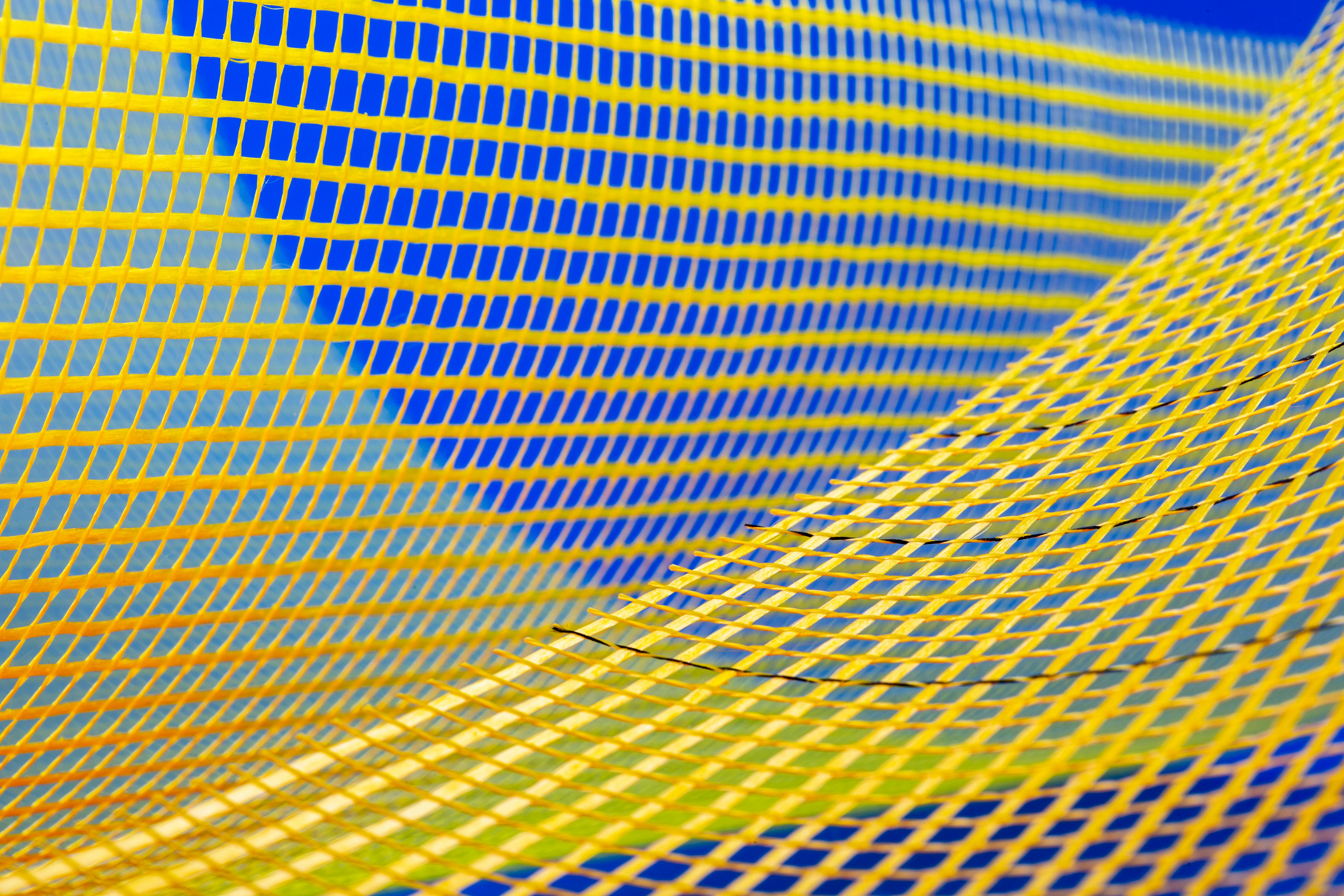 Zadarmo Abstraktný obrázok so žiarivým žltým a modrým sieťovaným vzorom vytvára dynamický vizuálny efekt. Fotka z fotobanky