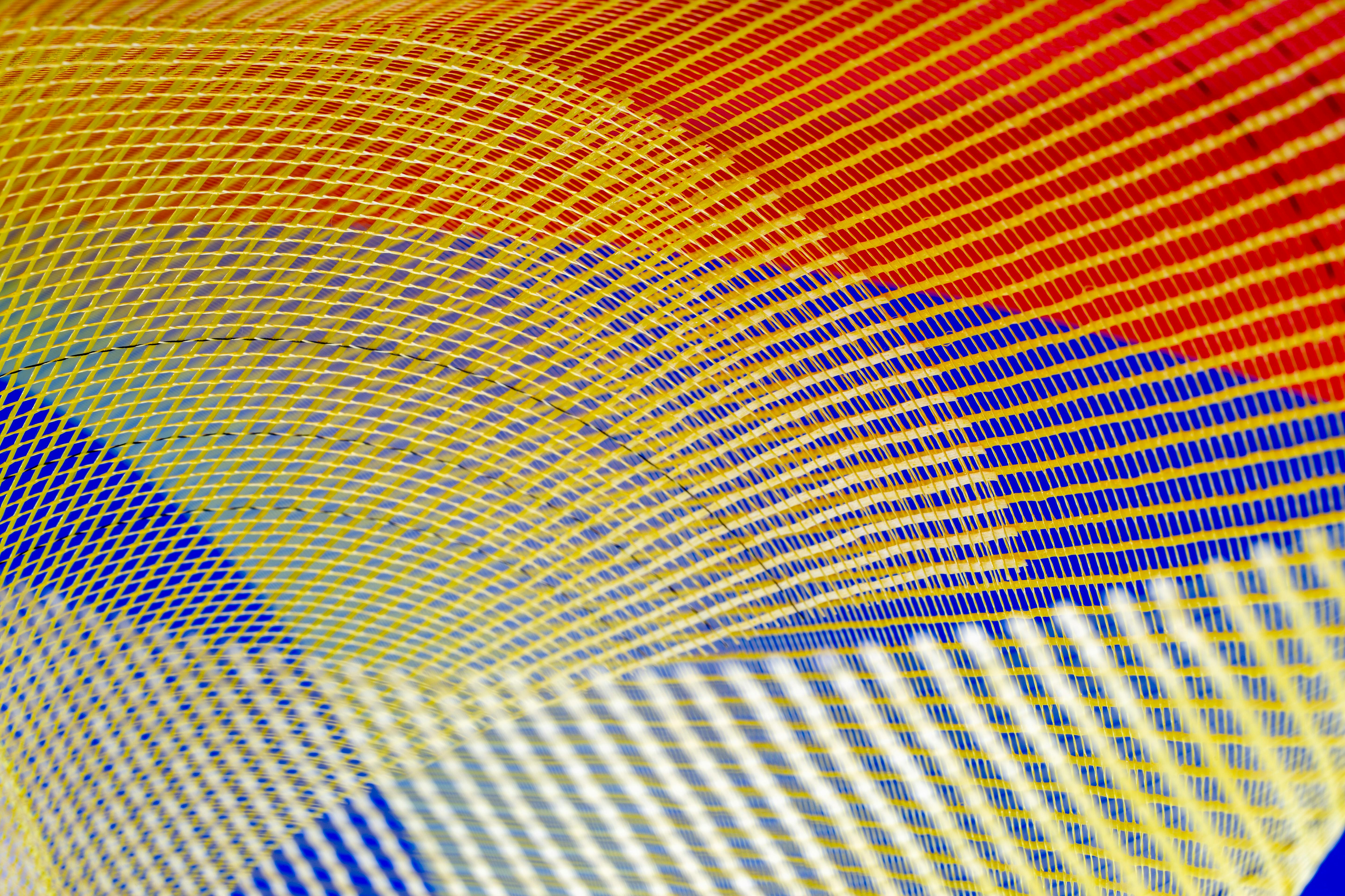 Безкоштовне Яскравий абстрактний дизайн з червоними, синіми та жовтими вигнутими лініями, що створює динамічний візуальний візерунок. стокове фото