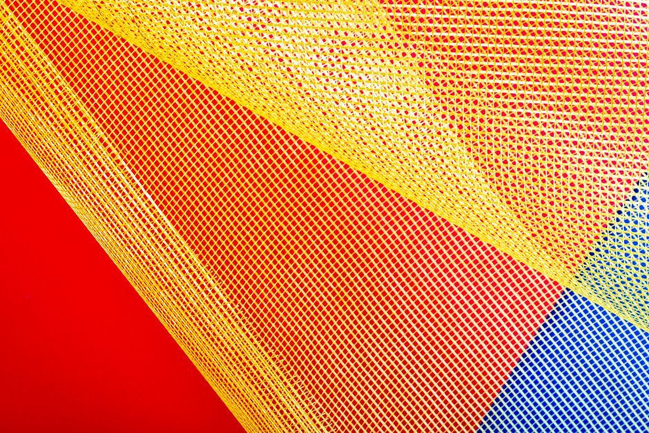 Dynamic abstract art featuring intersecting red, yellow, and blue mesh patterns. Dynamic abstract art featuring intersecting red, yellow, and blue mesh patterns.