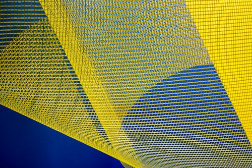 Free Dynamic abstract image featuring yellow mesh patterns against a deep blue background, creating an artistic visual. Stock Photo