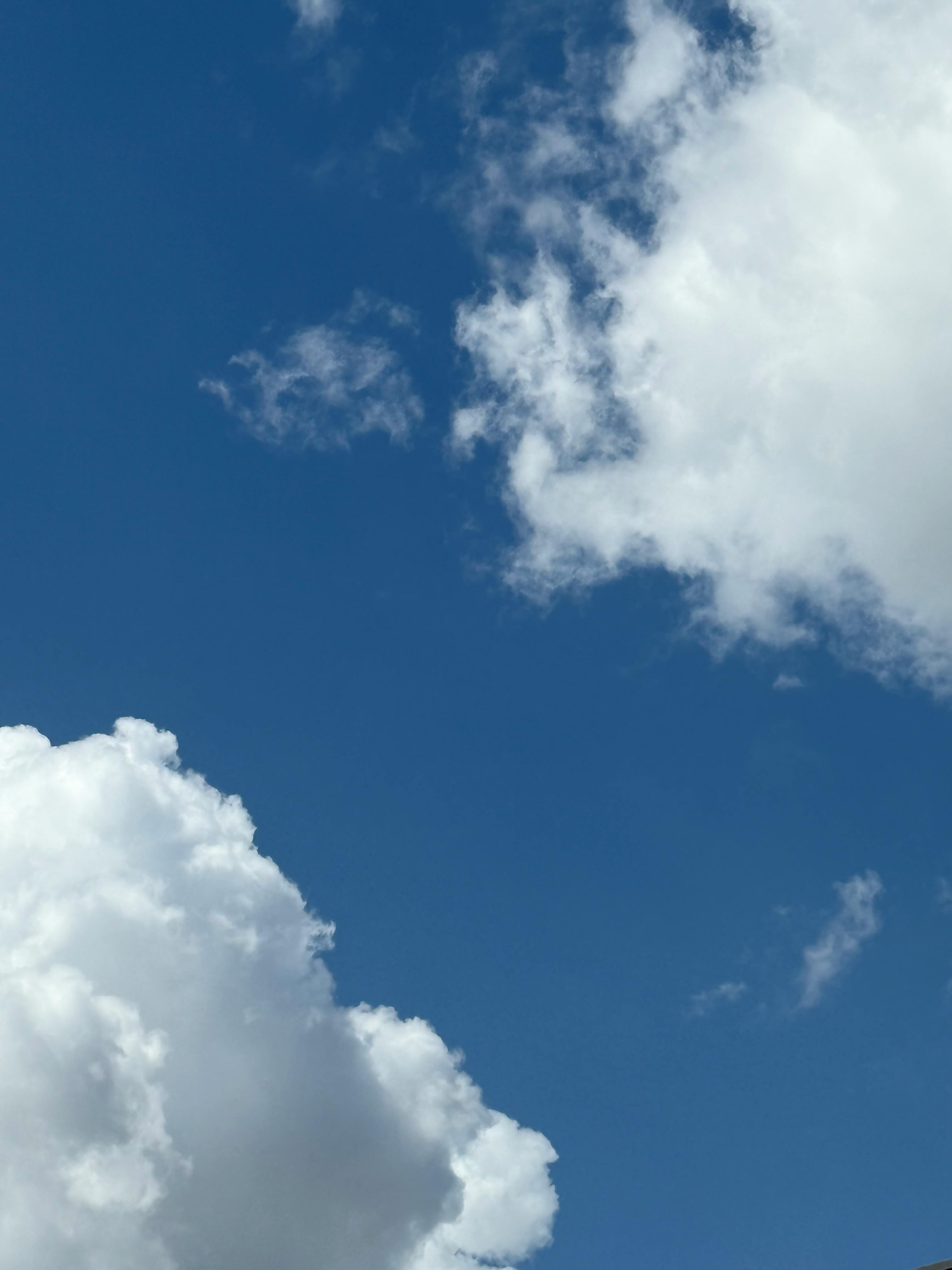 Безкоштовне Яскраве блакитне небо, наповнене білими хмарами, створює безтурботну атмосферу просто неба. стокове фото