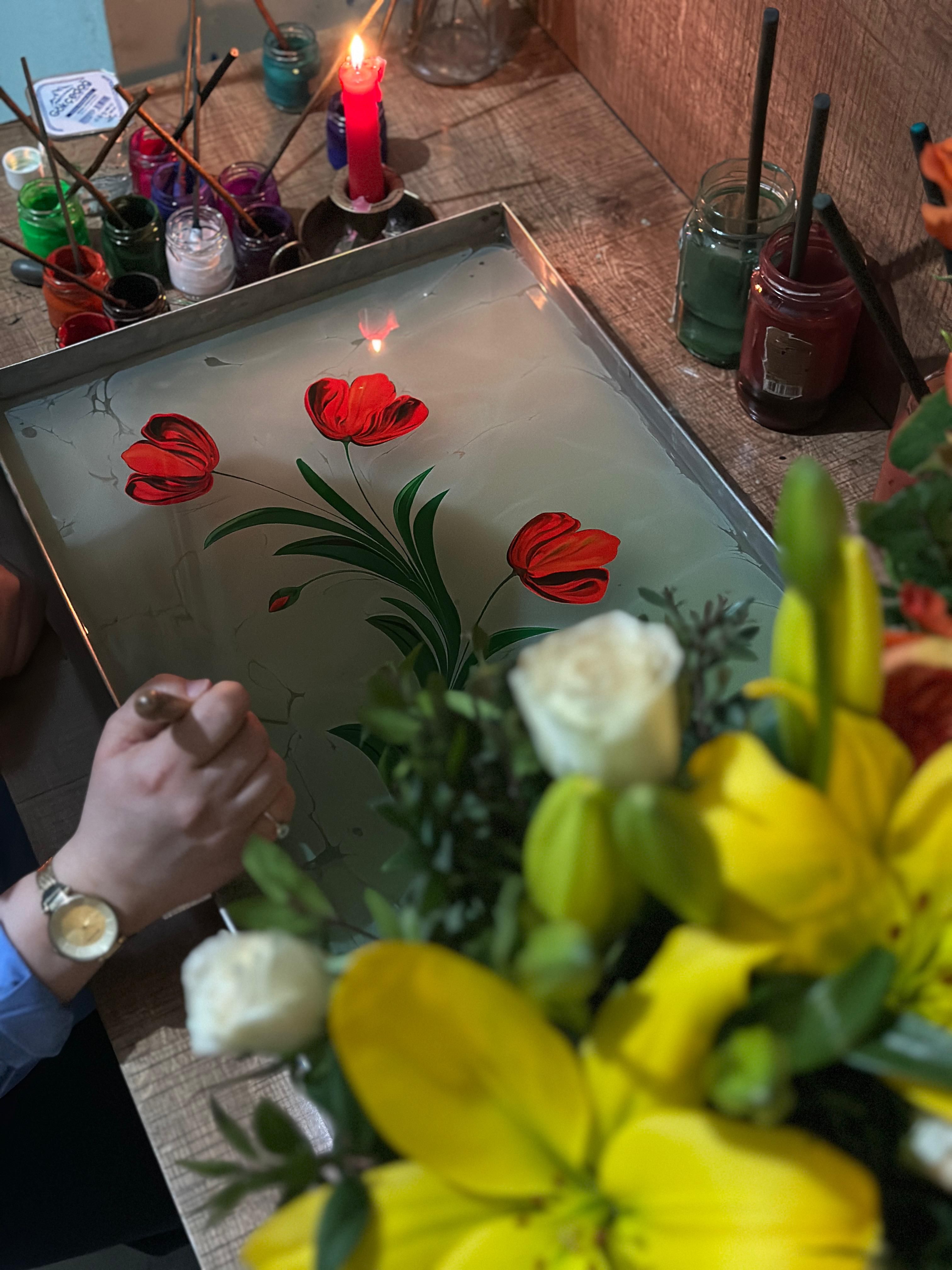 Capture the artistry of Ebru with vibrant red tulips crafted on water. An intricate painting technique.