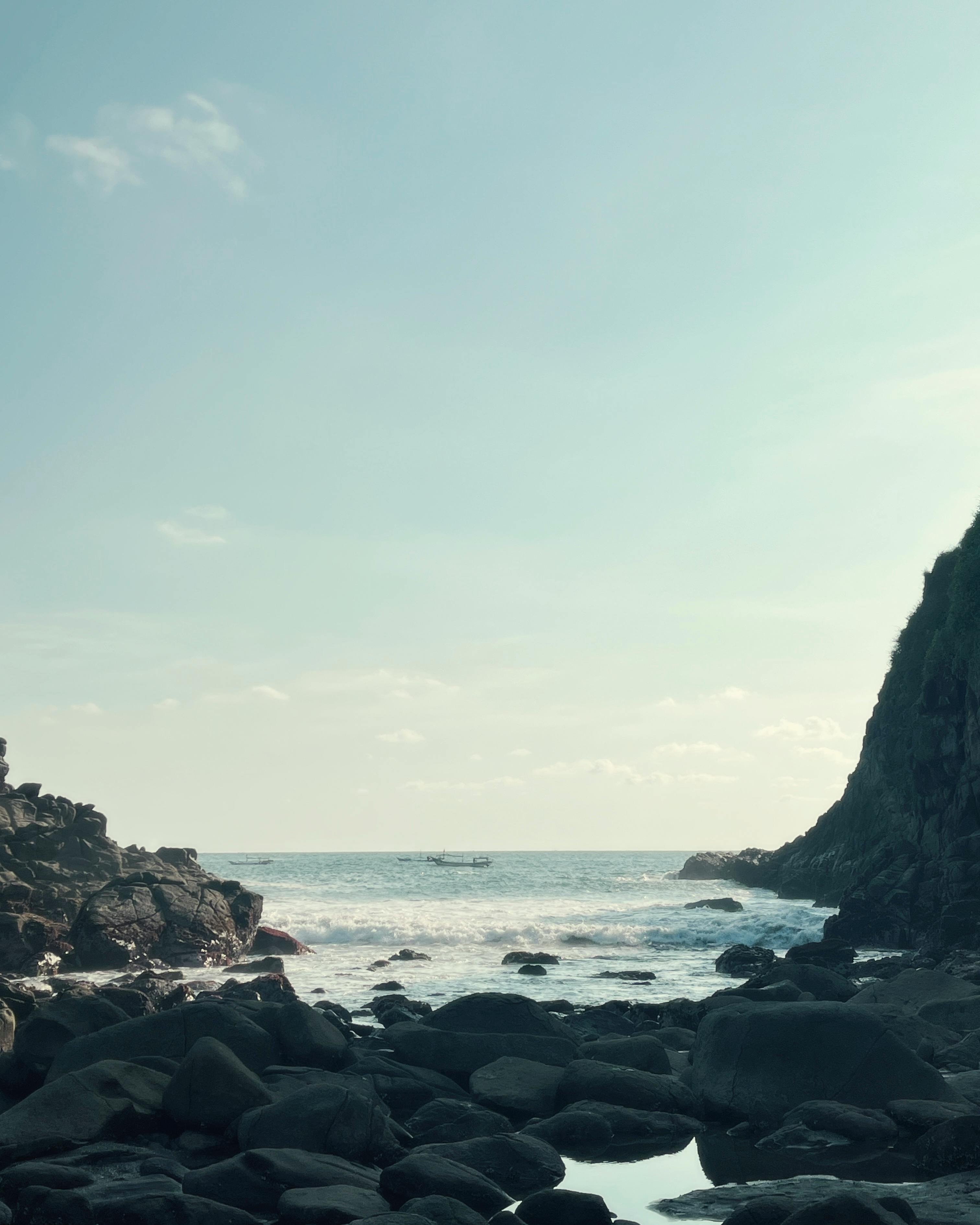 Kostnadsfria Idylliska kusten i Jawa Timur, Indonesien med klippiga klippor mot en fridfull havsutsikt. Stock foto