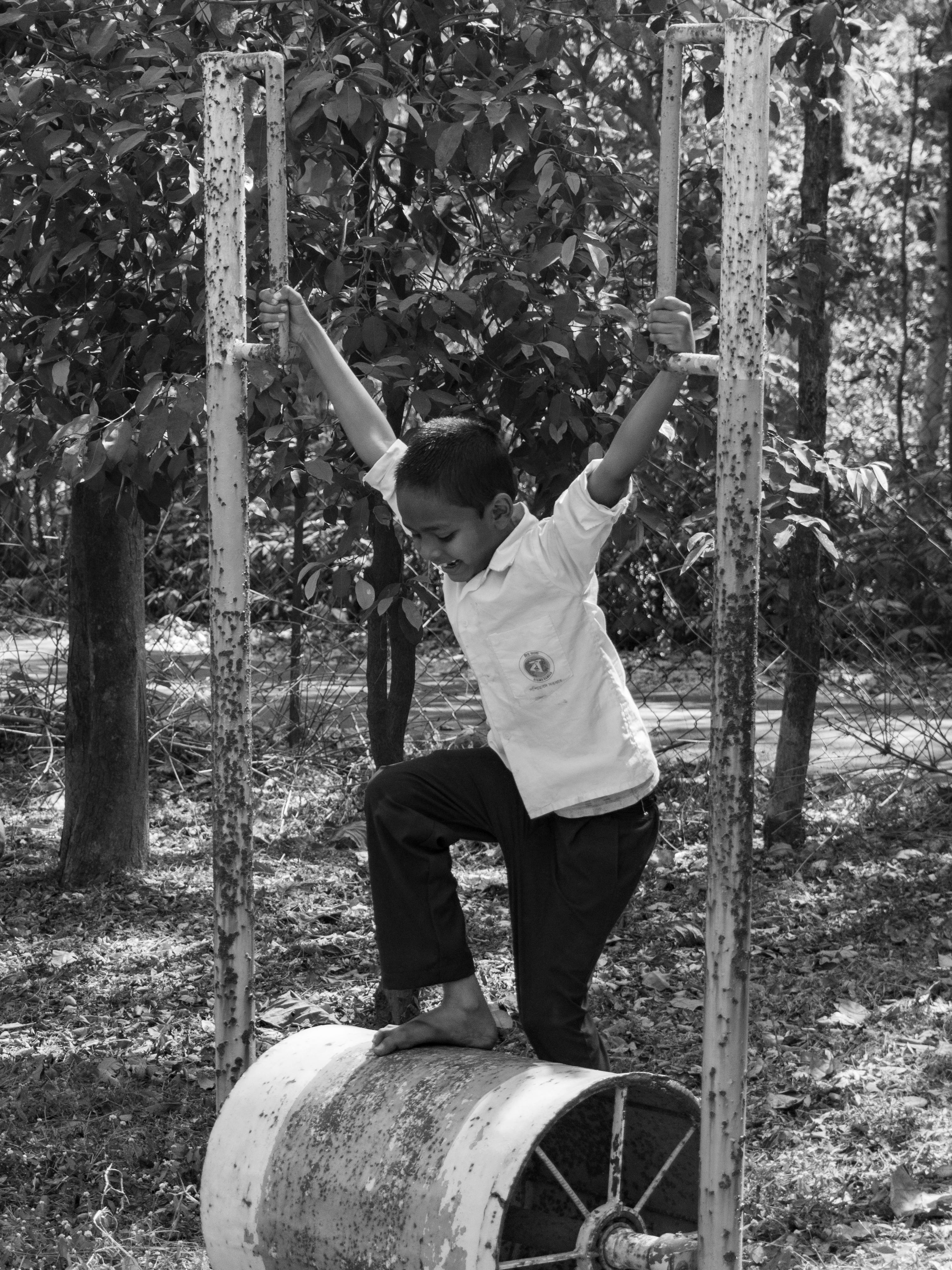 Miễn phí Hình ảnh đen trắng cho thấy một đứa trẻ đang chơi đùa và giữ thăng bằng trên thiết bị sân chơi cổ điển ngoài trời. Ảnh lưu trữ