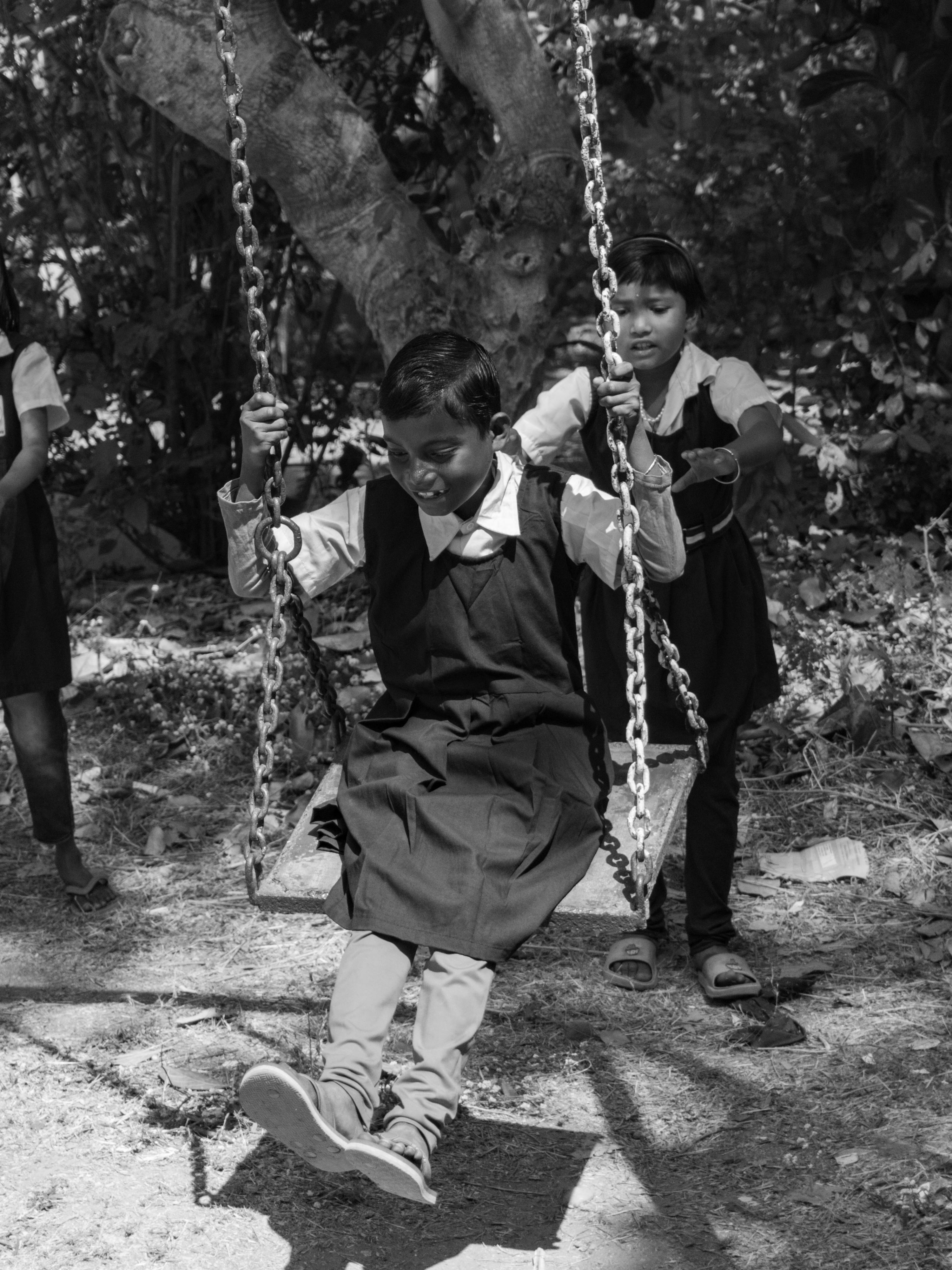 ฟรี ภาพถ่ายขาวดำของเด็กๆ กำลังสนุกสนานกับชิงช้าในสนามเด็กเล่น แสดงออกถึงความสุขและความสนุกสนานในวัยเด็ก คลังภาพถ่าย