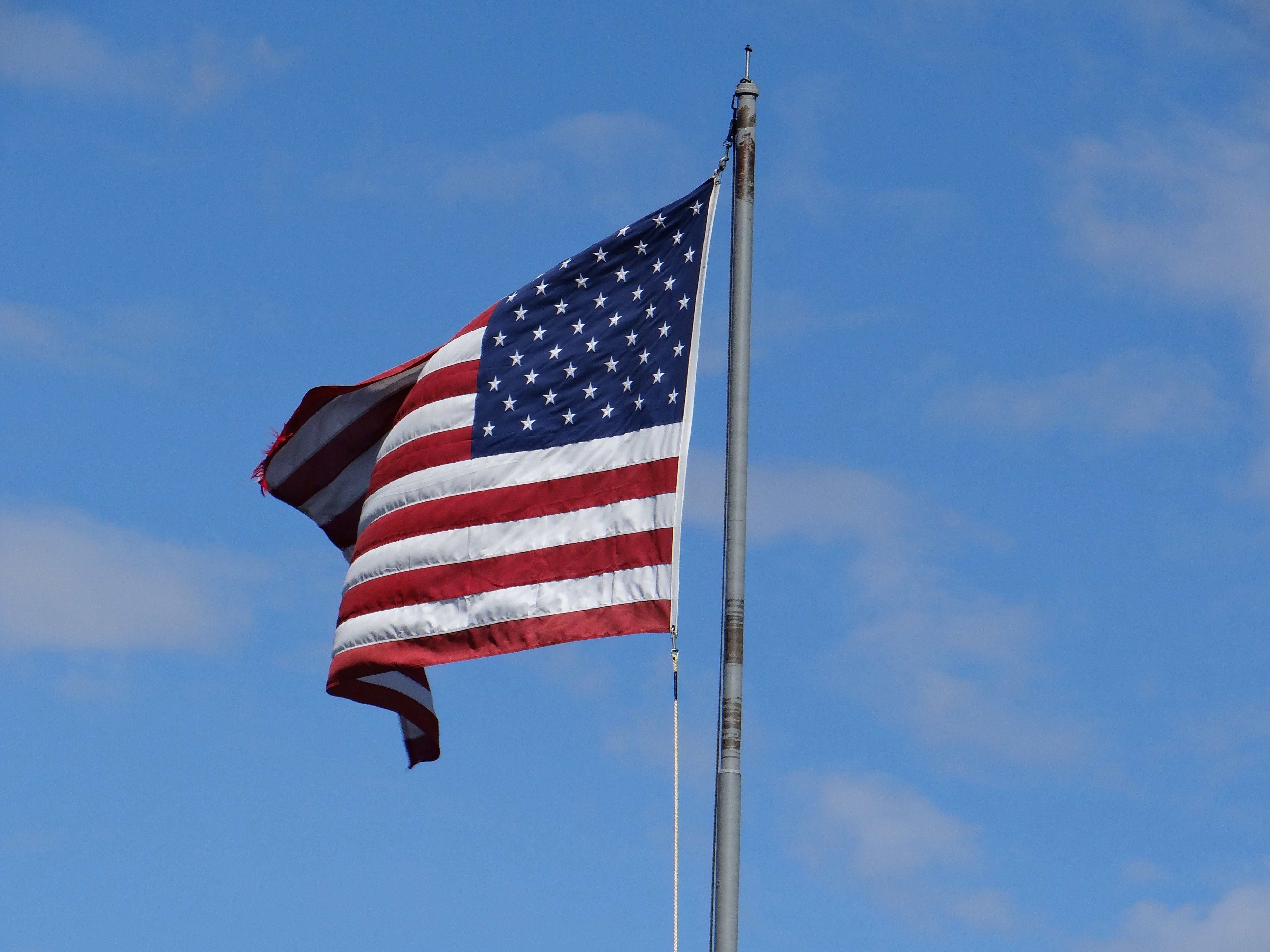 US flag flying in clear blue sky at Mackinac Island, MI. Symbol of American patriotism.