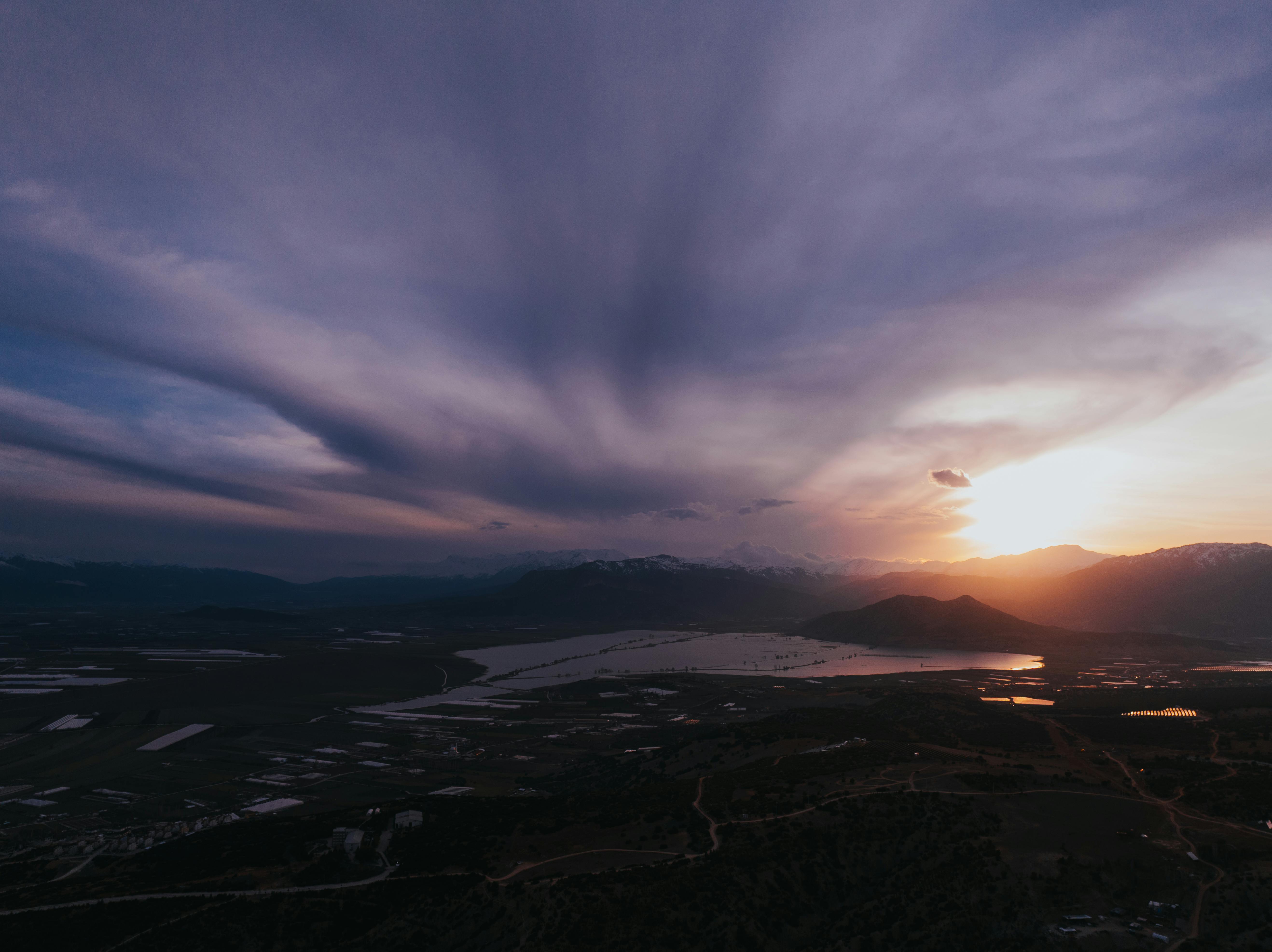 Gratis Una vista aerea mozzafiato di uno splendido tramonto su un lago tranquillo, con formazioni nuvolose di grande effetto. Foto a disposizione