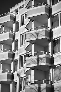 Stylish black and white photo of a modern apartment building with balconies.