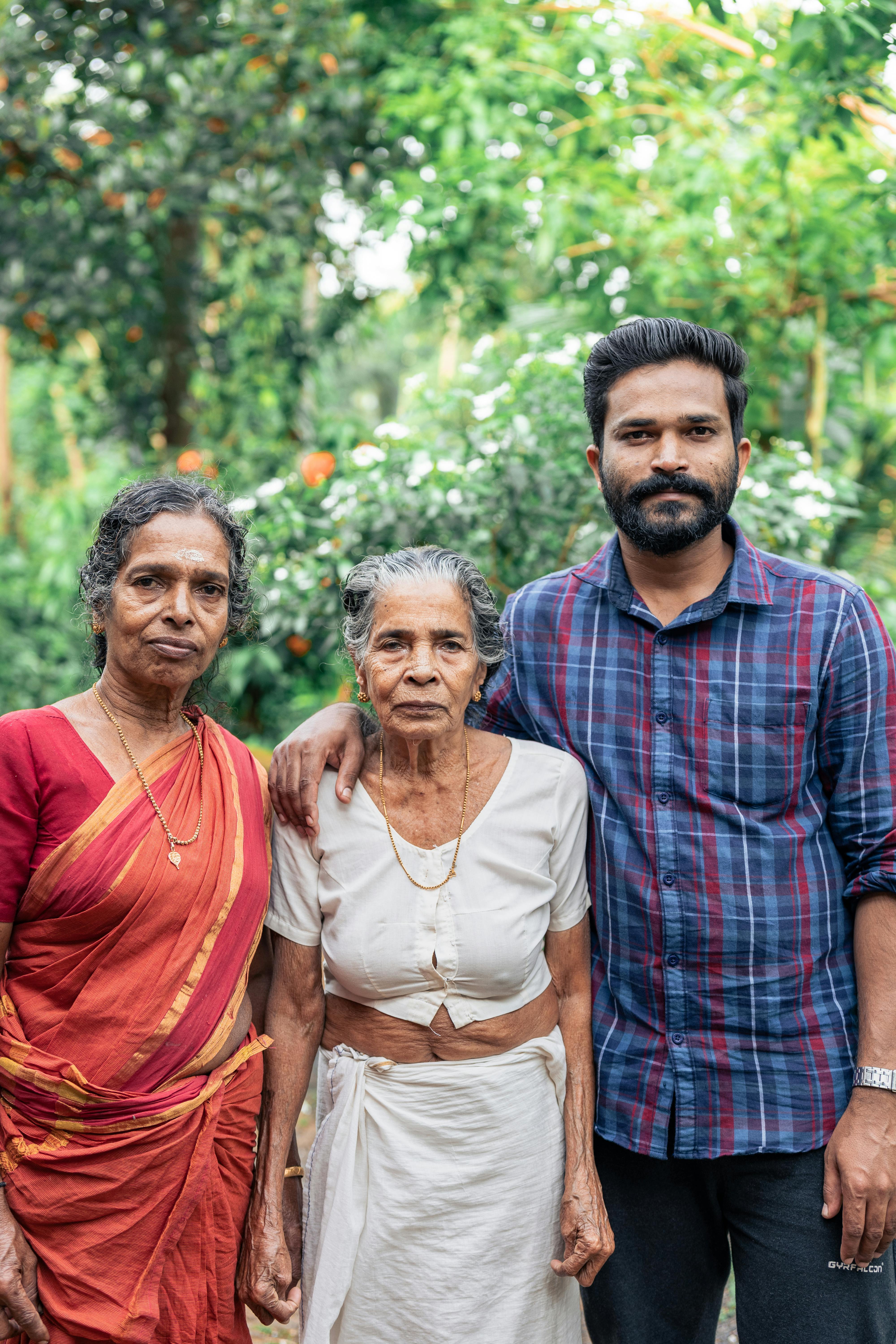 Miễn phí Ba thế hệ cùng nhau tạo dáng trong một khung cảnh ngoài trời xanh mát, thể hiện sự gắn kết gia đình. Ảnh lưu trữ