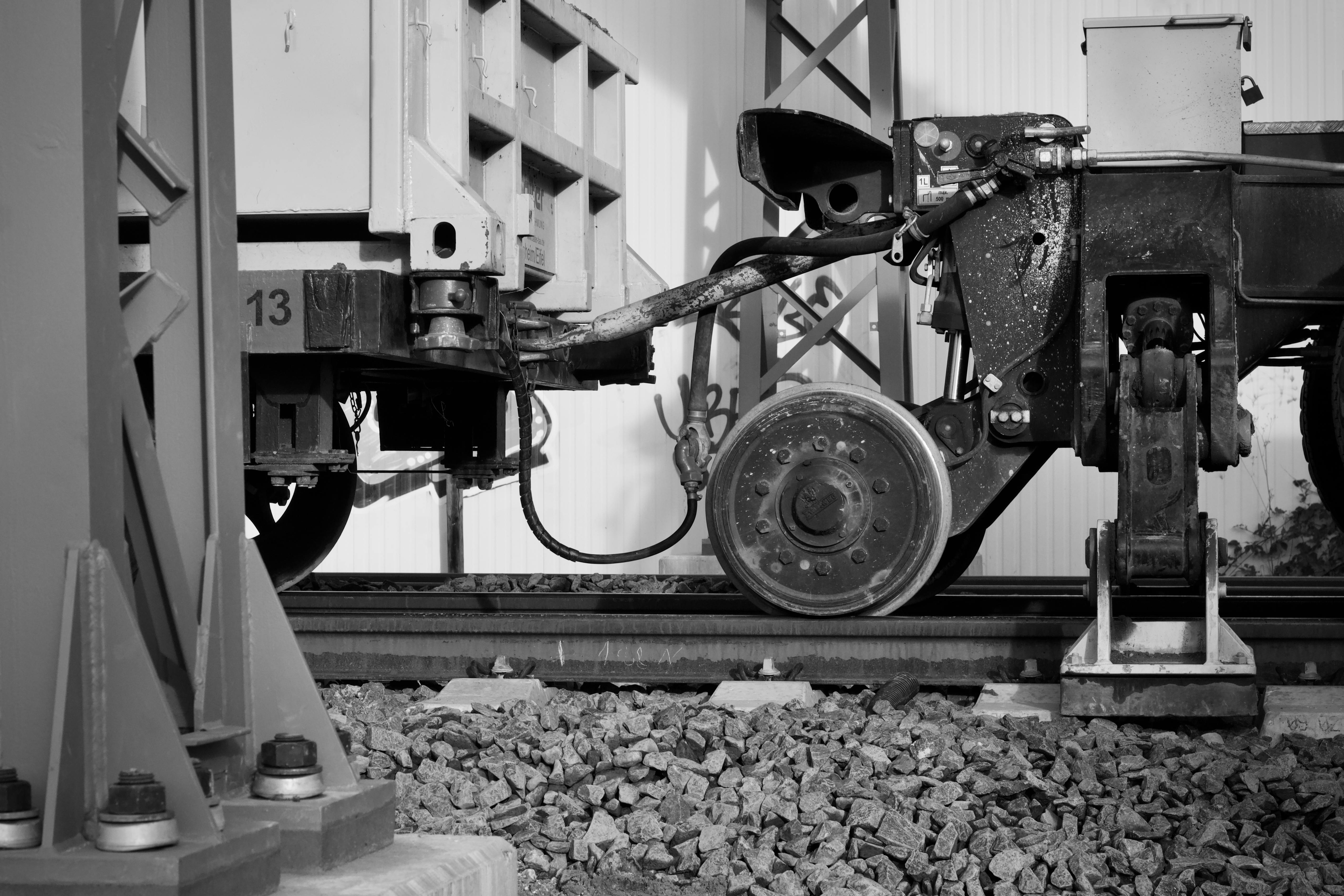 Δωρεάν Λεπτομερής ασπρόμαυρη φωτογραφία του μηχανισμού ζεύξης βαγονιών τρένων στις γραμμές. Φωτογραφία από στοκ φωτογραφιών