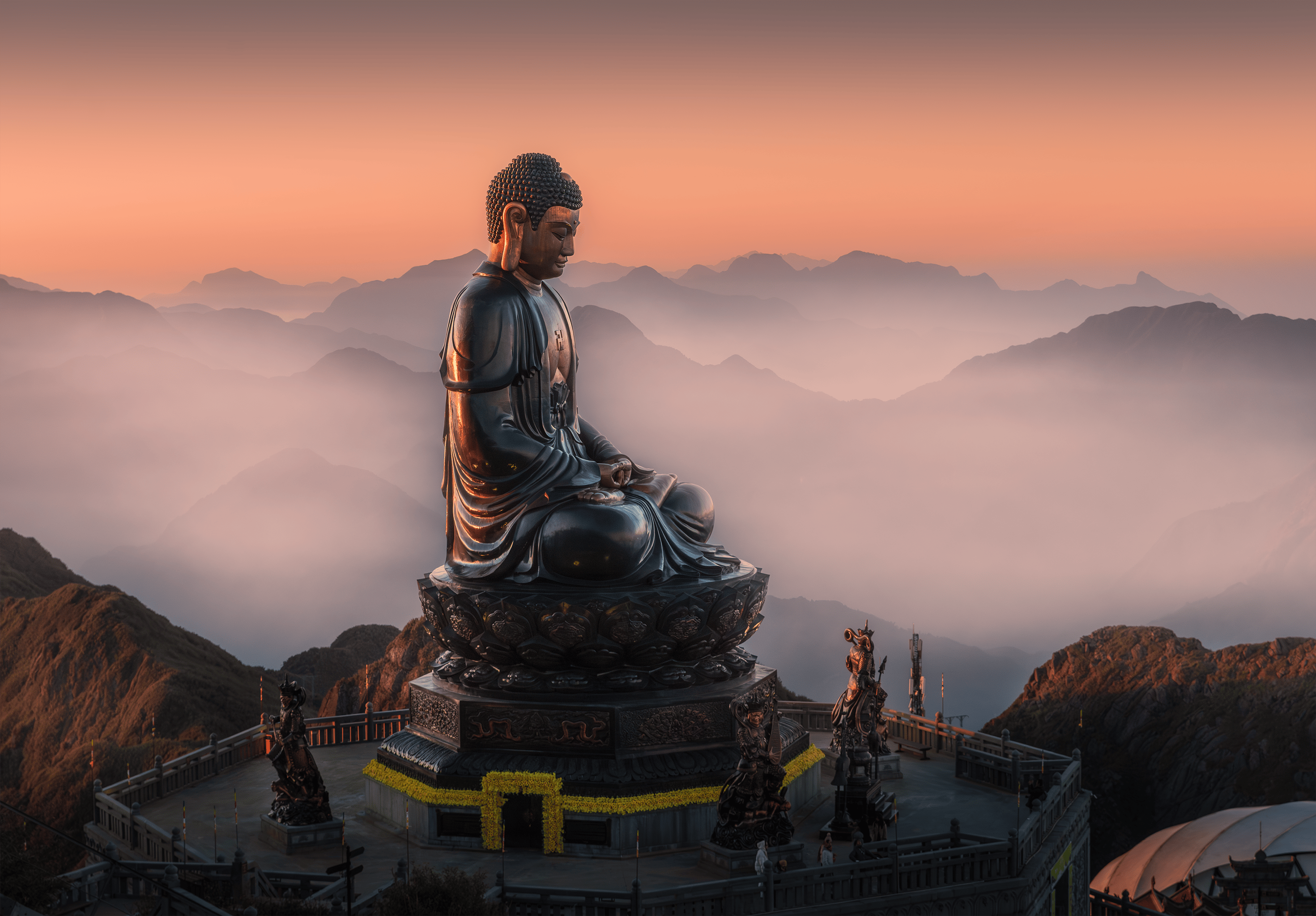 免费 日出时分，云雾缭绕的山峦间，一尊宁静祥和的佛像散发着平和与宁静的气息。 素材图片