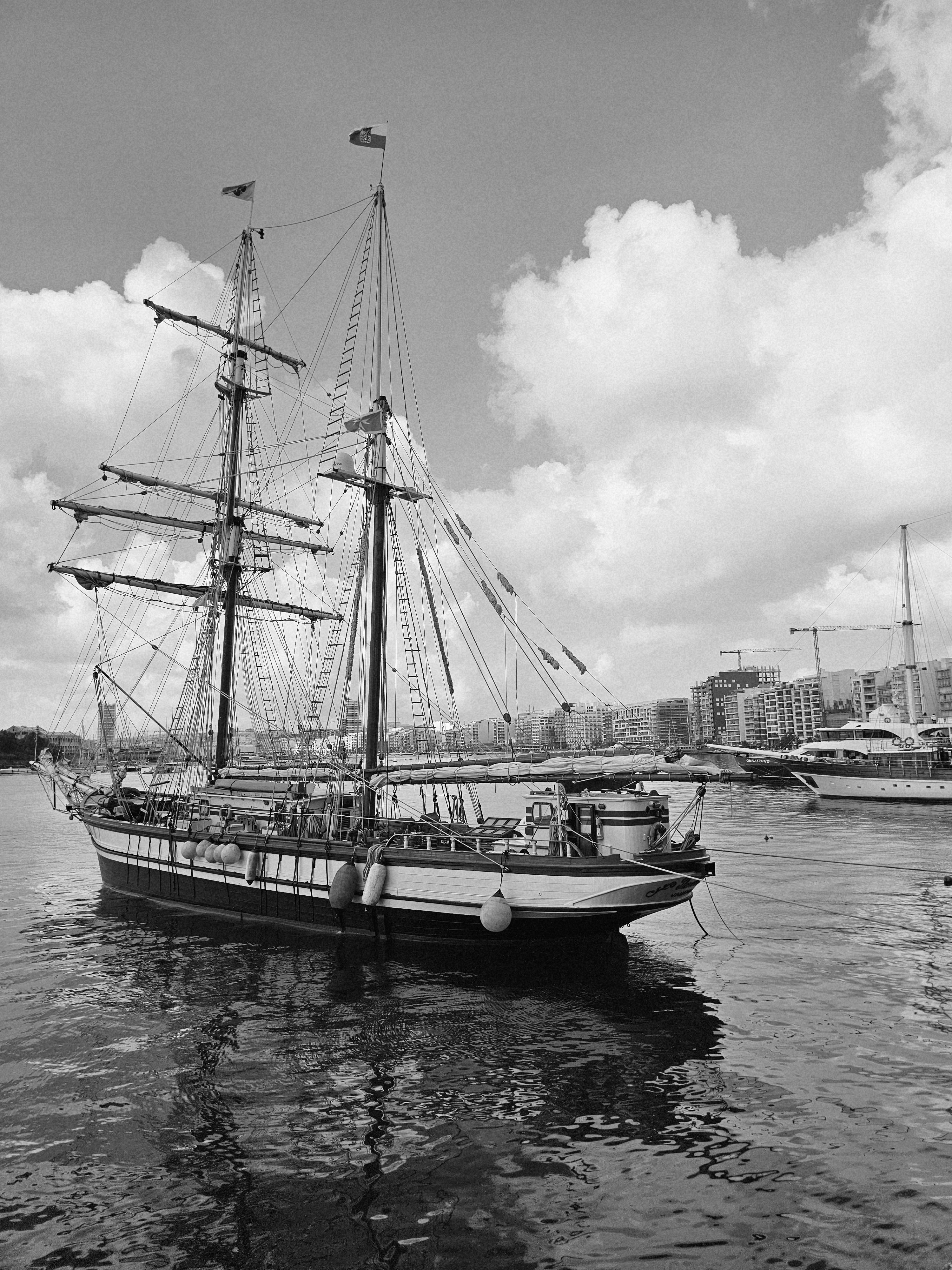 bezplatná Historická vysoká loď zakotvená v rušném městském přístavu s moderní panoramatickou kulisou. Základová fotografie