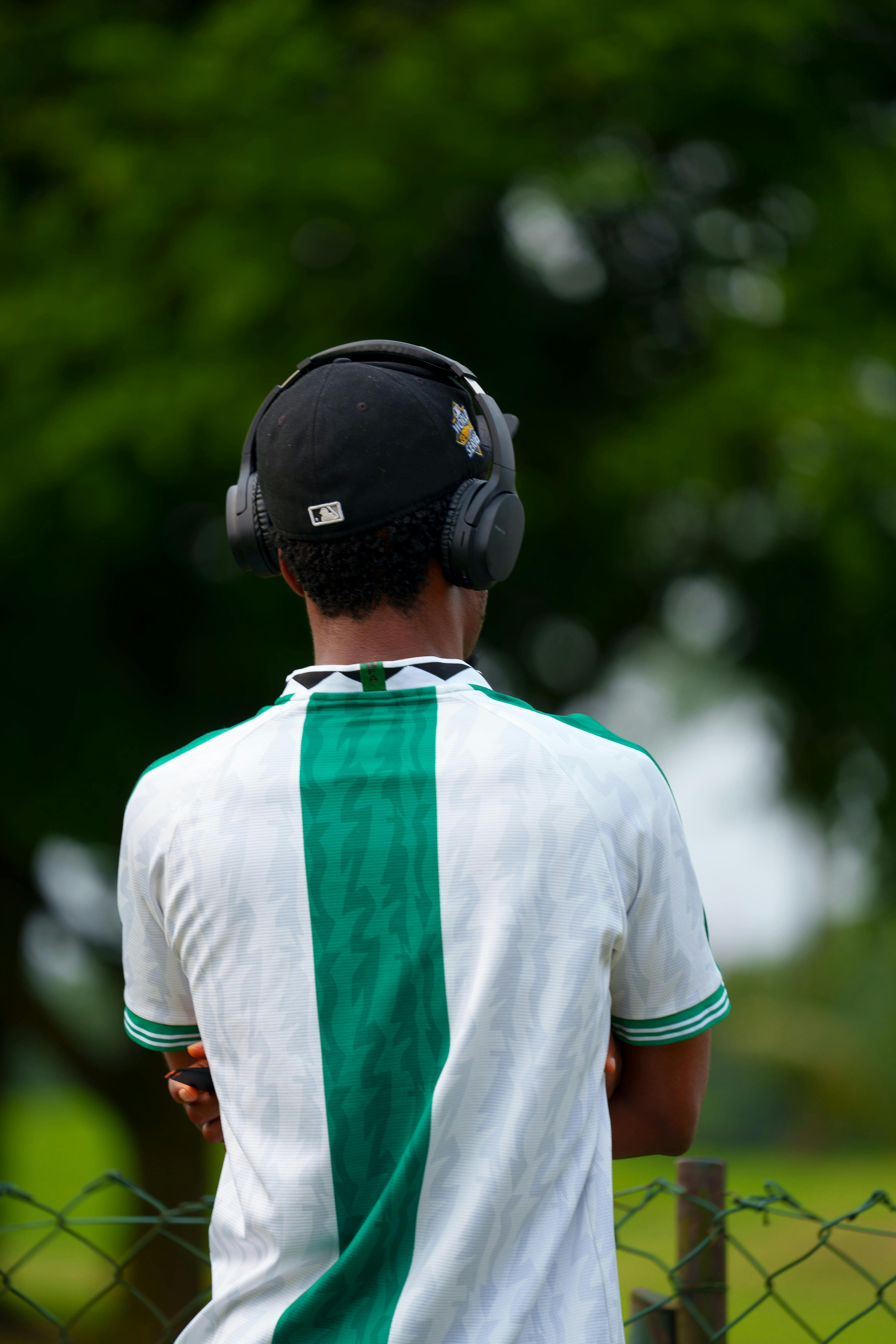 Gratuit Vue de dos d'un jeune homme portant des écouteurs à l'extérieur par une journée ensoleillée. Photos