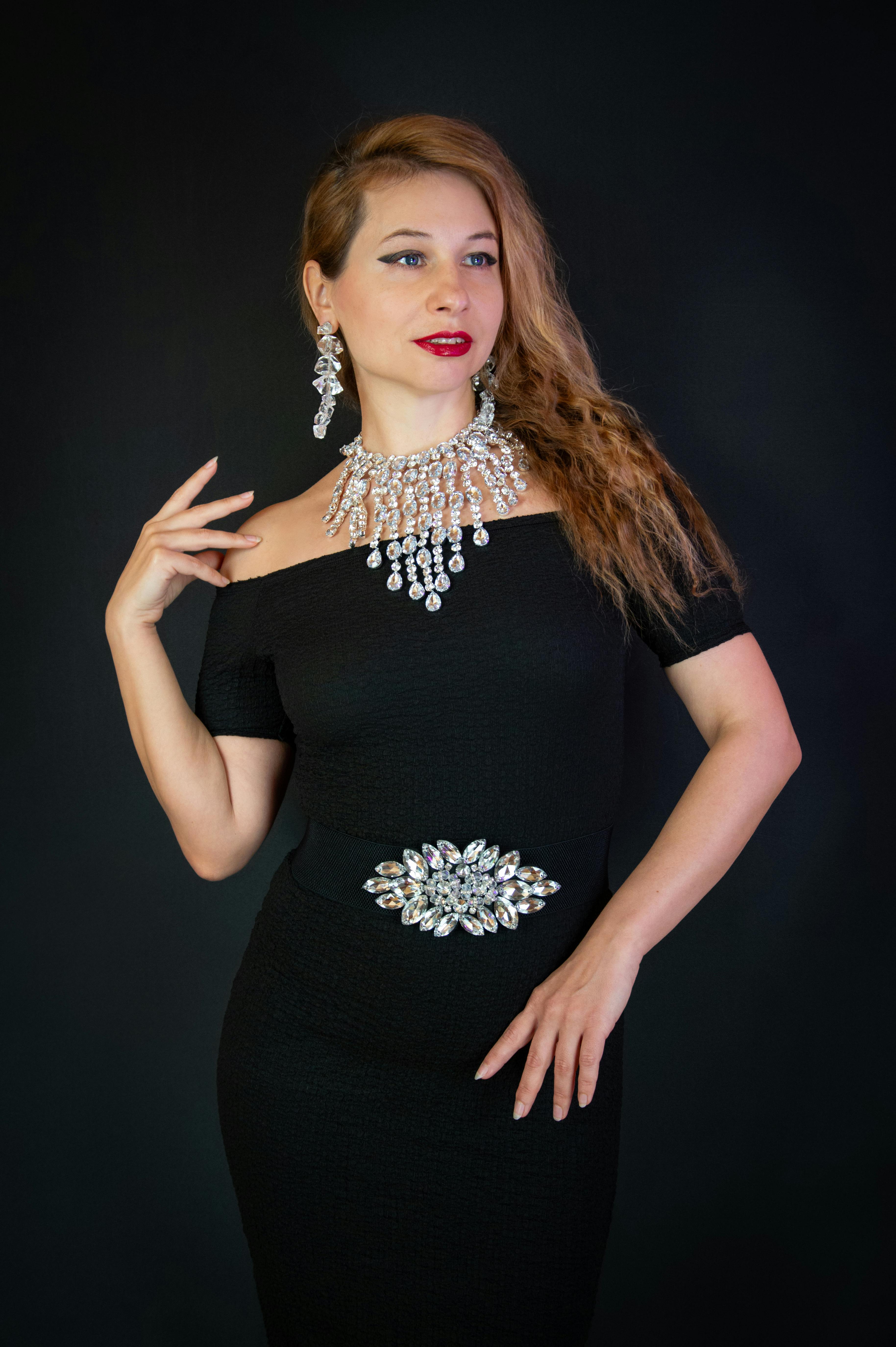 Gratuit Portrait de mode d'une femme élégante en robe noire ornée de bijoux raffinés, parfaite pour les occasions glamour. Photos