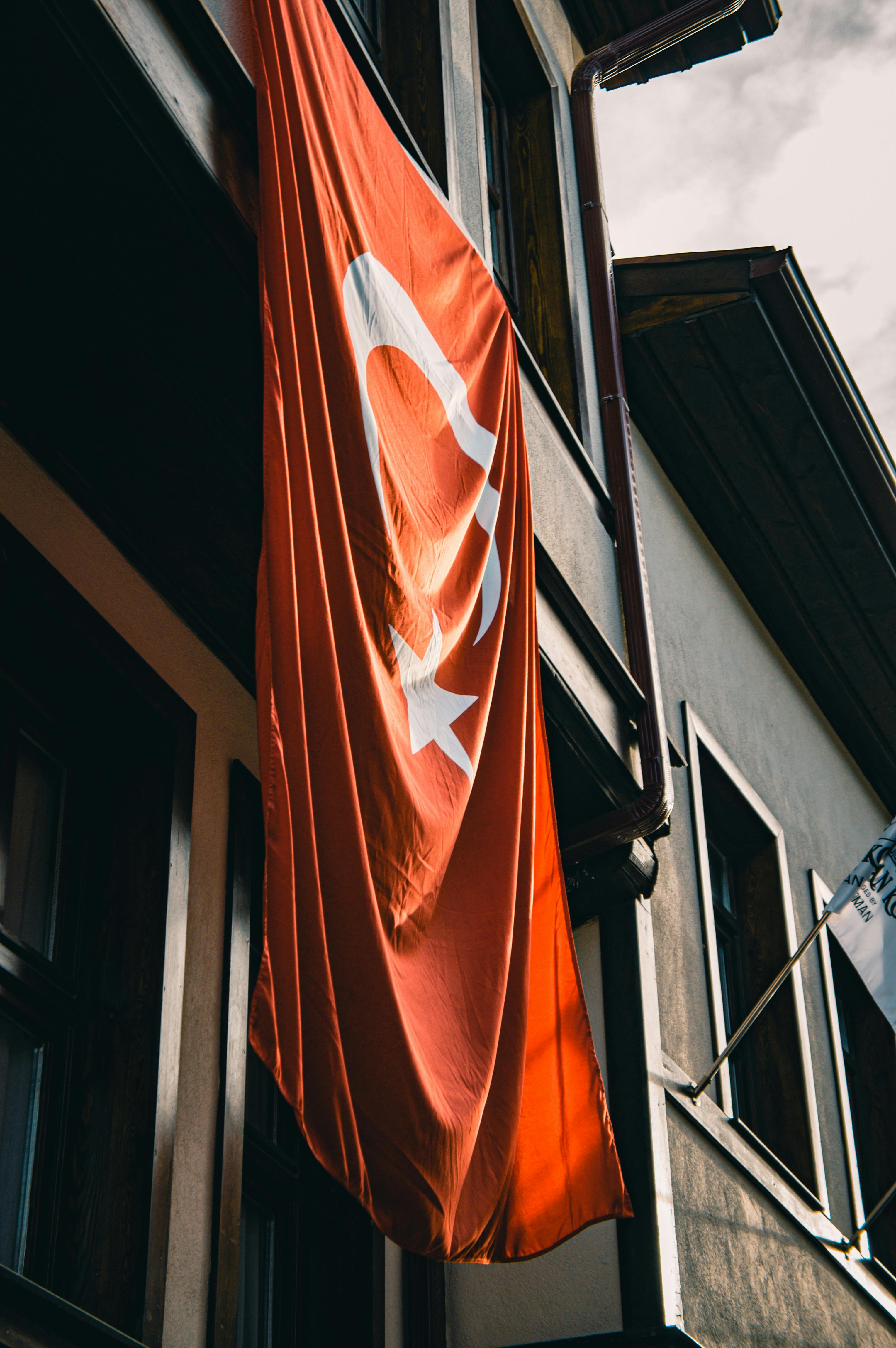grátis Bandeira turca hasteada na fachada de um edifício tradicional, enfatizando o patrimônio cultural. Foto profissional
