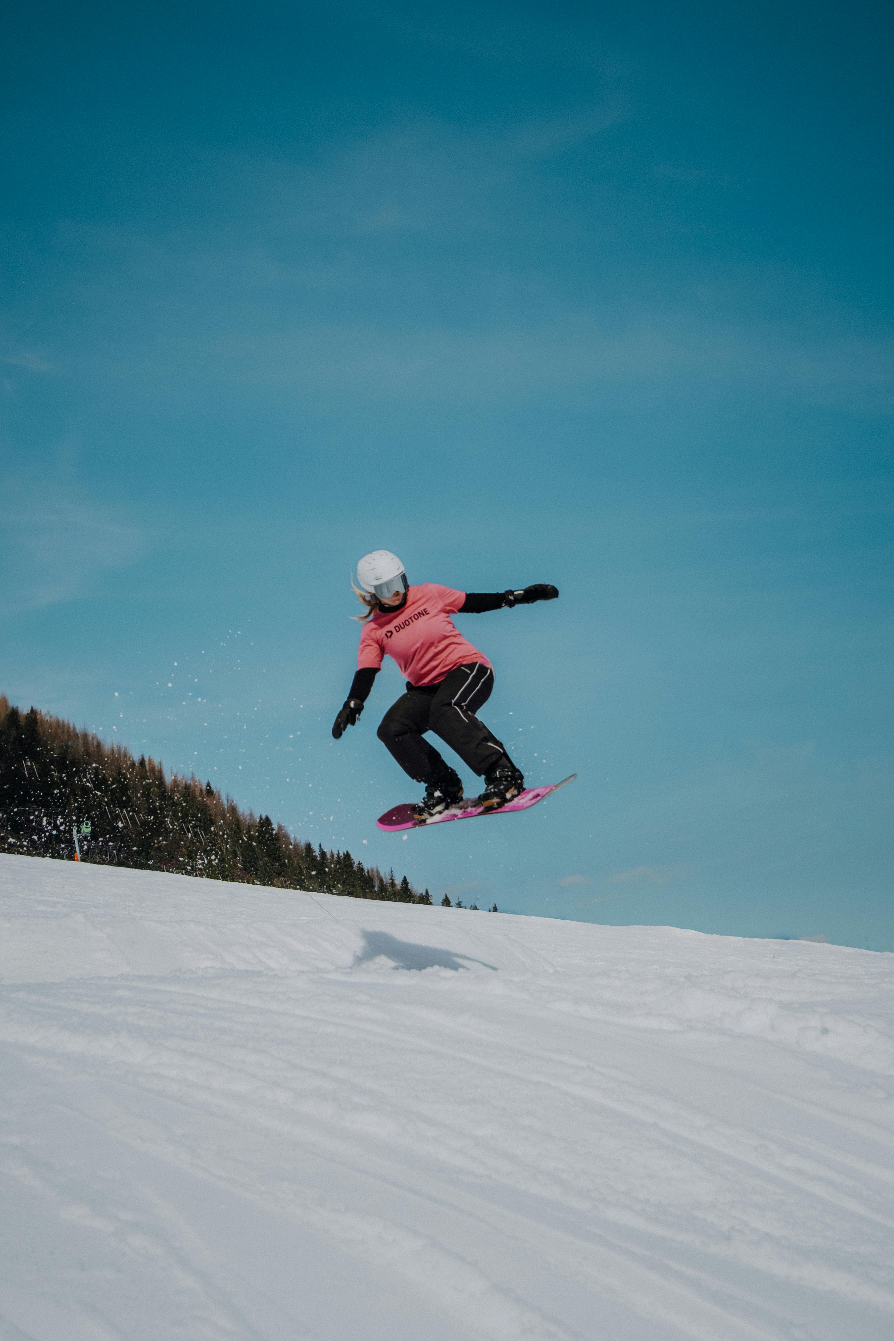 bezplatná Snowboardista skáče vysoko v zasněžených horách Tyrolska pod jasnou modrou oblohou. Základová fotografie