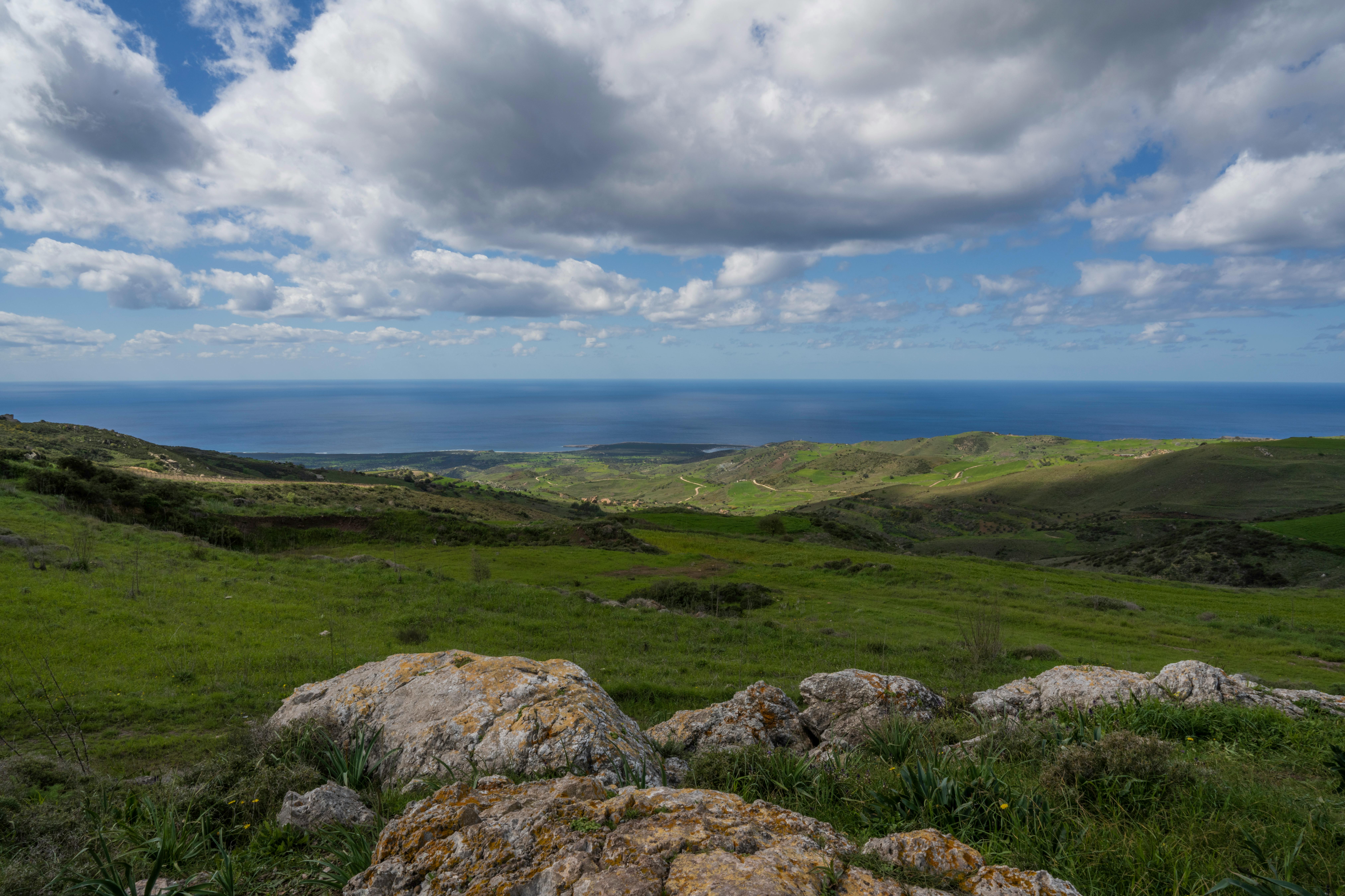 Gratis Una vista mozzafiato della costa di Cipro con colline verdi e cielo nuvoloso. Foto a disposizione