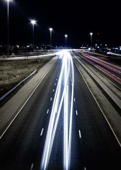 Aerial view of light trails on a highway in London, Ontario at night, capturing the essence of fast-moving traffic.