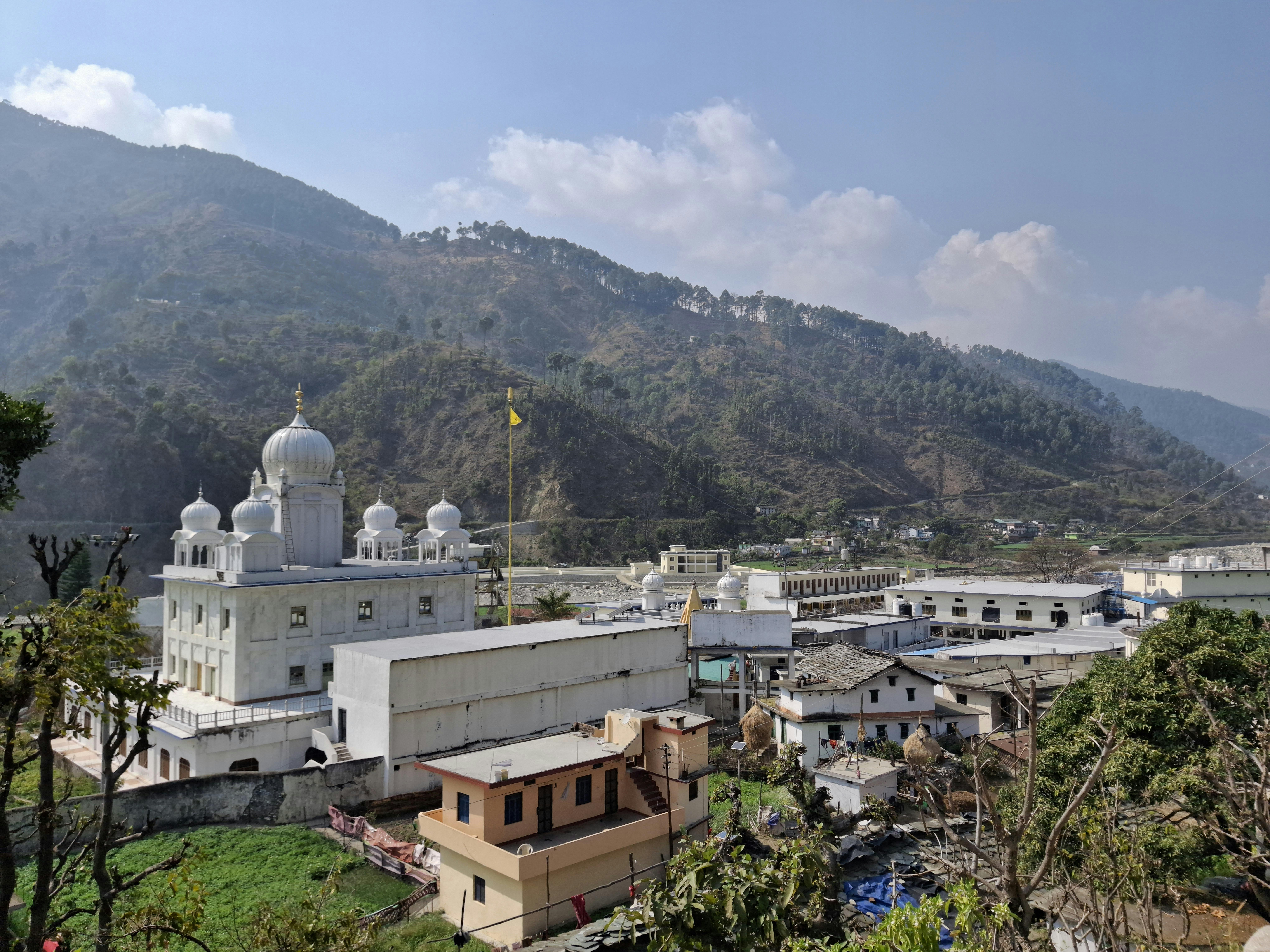 Bezpłatne Gurdwara otoczona malowniczym górskim krajobrazem pod czystym, błękitnym niebem. Zdjęcie z galerii