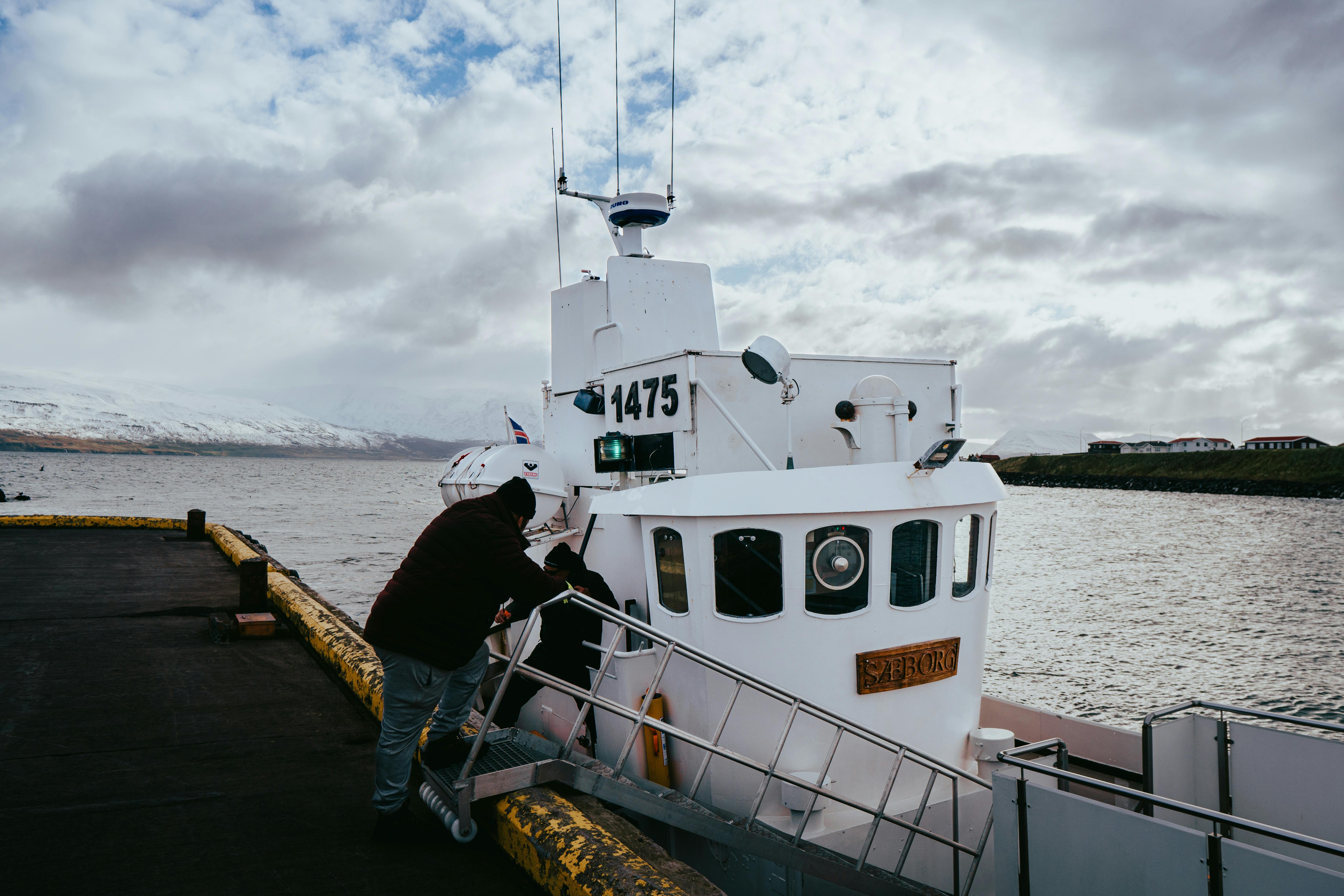 bezplatná Loď zakotvila v Árskógssandur v zasněženém islandském fjordu a zachytila ​​zimní scenérii. Základová fotografie