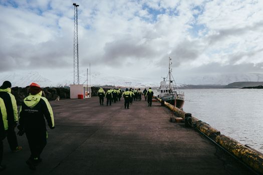 Group of tourists ready for a whale watching tour at Árskógssandur harbor, Iceland.