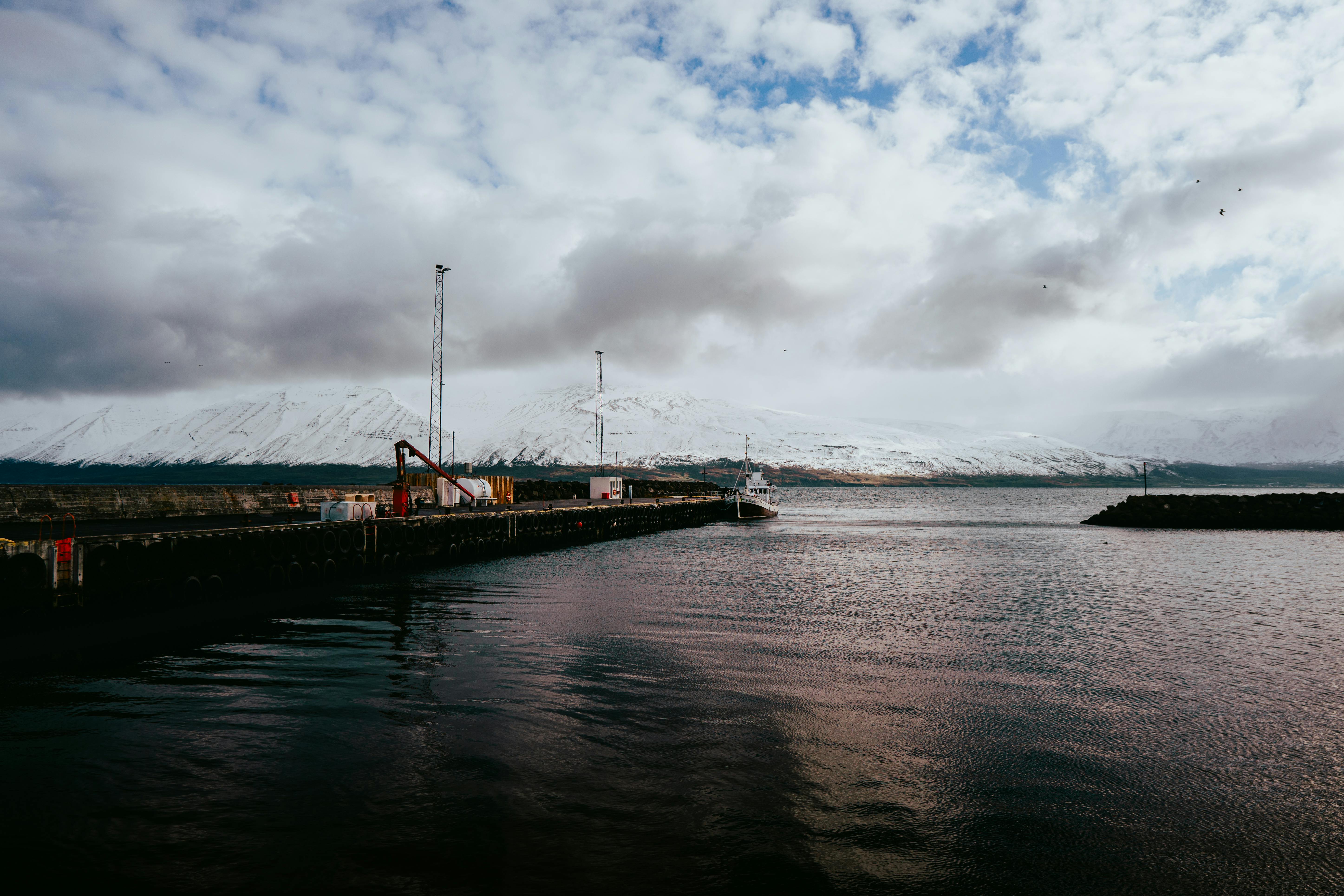 Stunning landscape of Árskógssandur fjord, Iceland, showcasing snow-capped mountains and tranquil wa