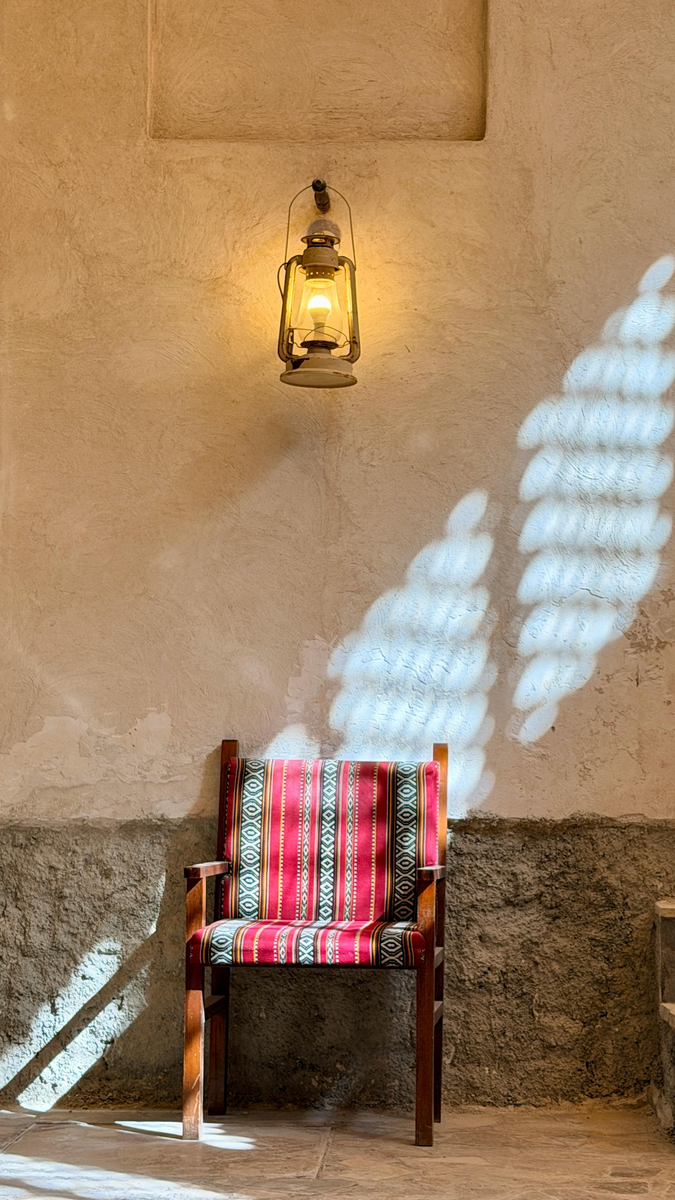 Gratis Illuminazione soffusa di una sedia di legno grazie a una lanterna a Dubai, che mette in risalto l'arredamento tradizionale mediorientale. Foto a disposizione