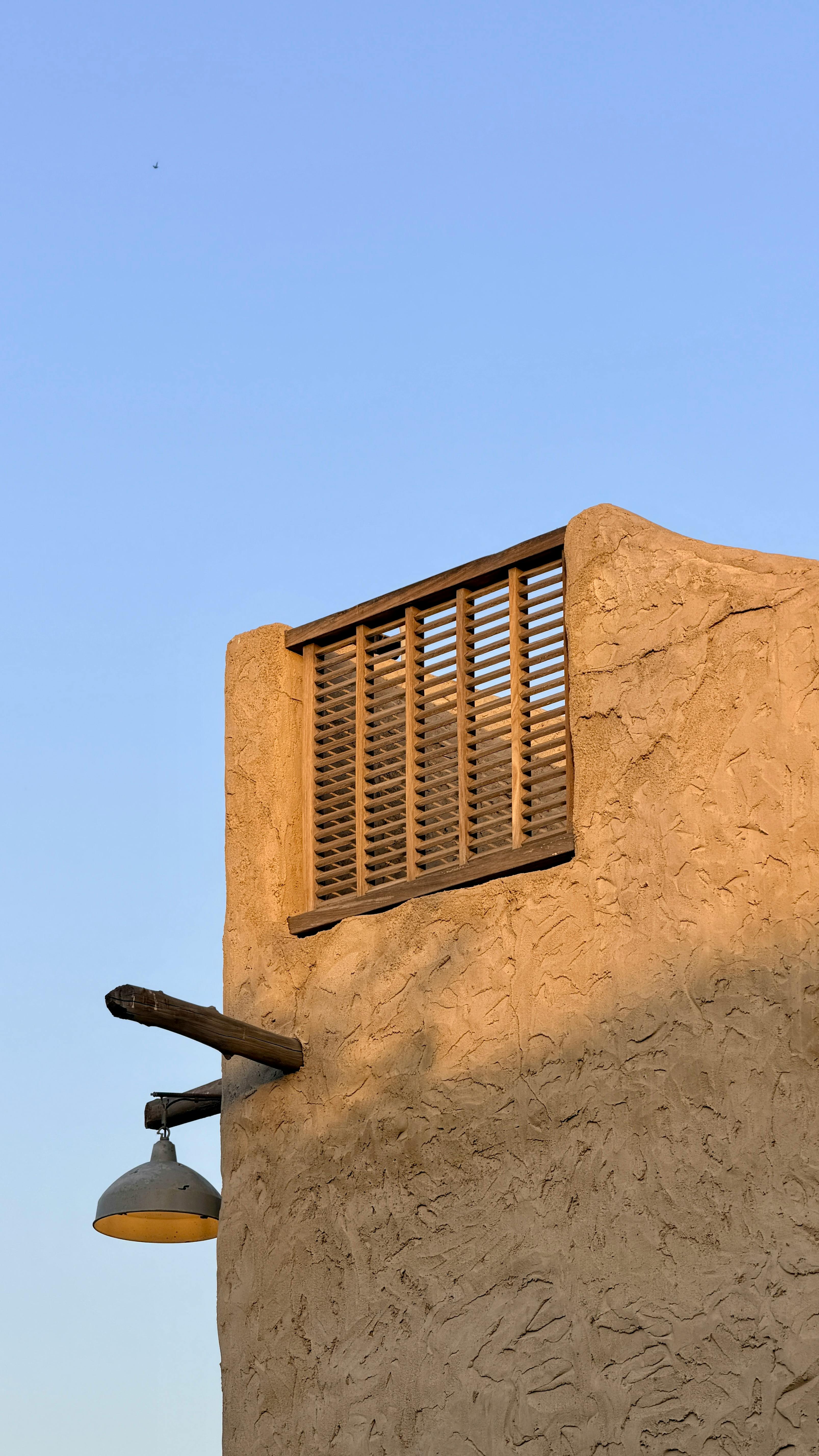 Kostenlos Ein im warmen Licht des Sonnenuntergangs erstrahlendes Gebäude im Adobe-Stil in Dubai, das traditionelle Architektur des Nahen Ostens präsentiert. Stock-Foto