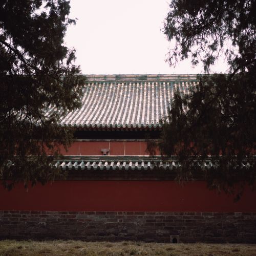 Free Ancient Chinese temple with distinctive roof in Beijing, framed by trees. Stock Photo