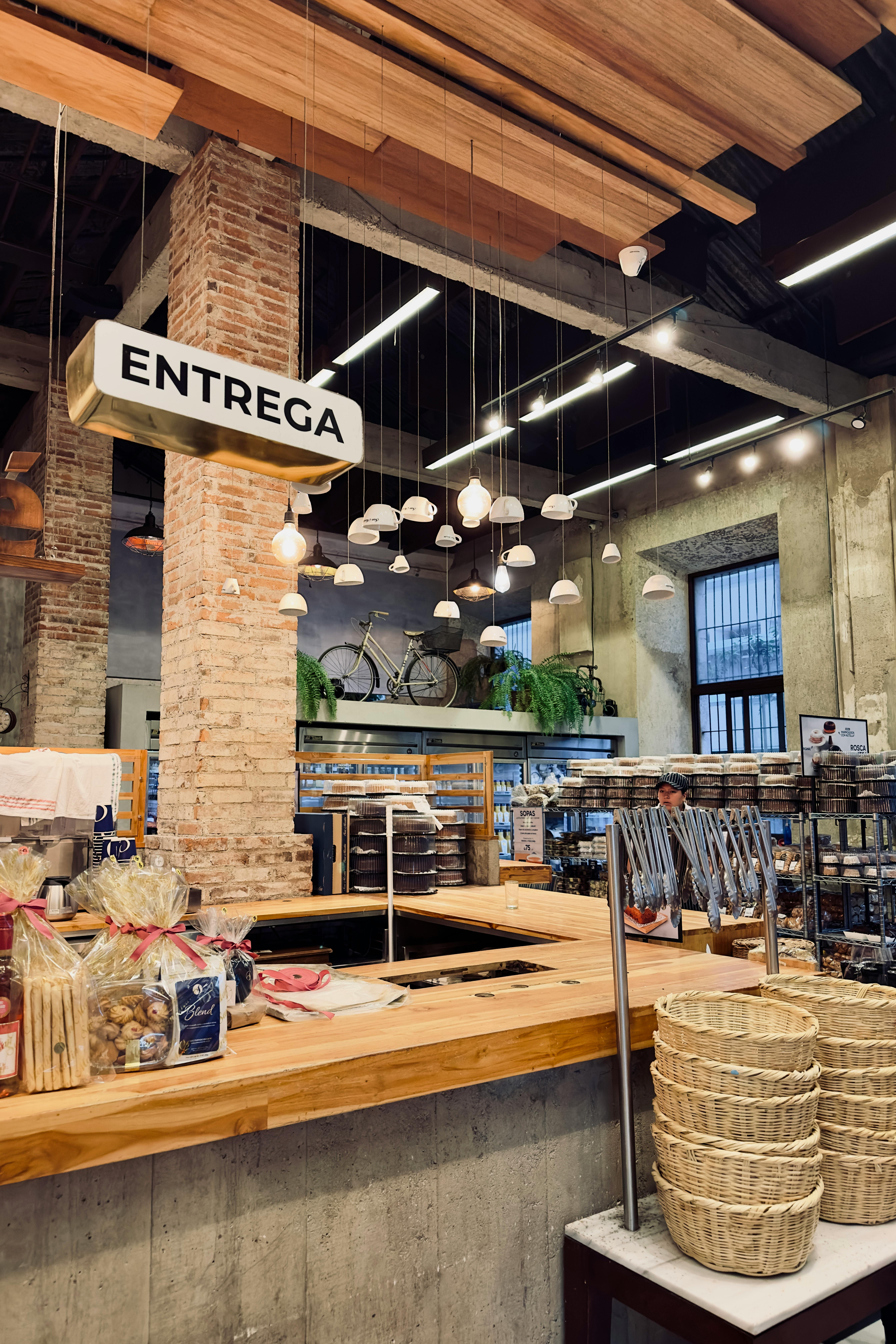 Gratuit Un café chaleureux avec des murs en briques, des guirlandes lumineuses et un comptoir de livraison avec des paniers. Photos