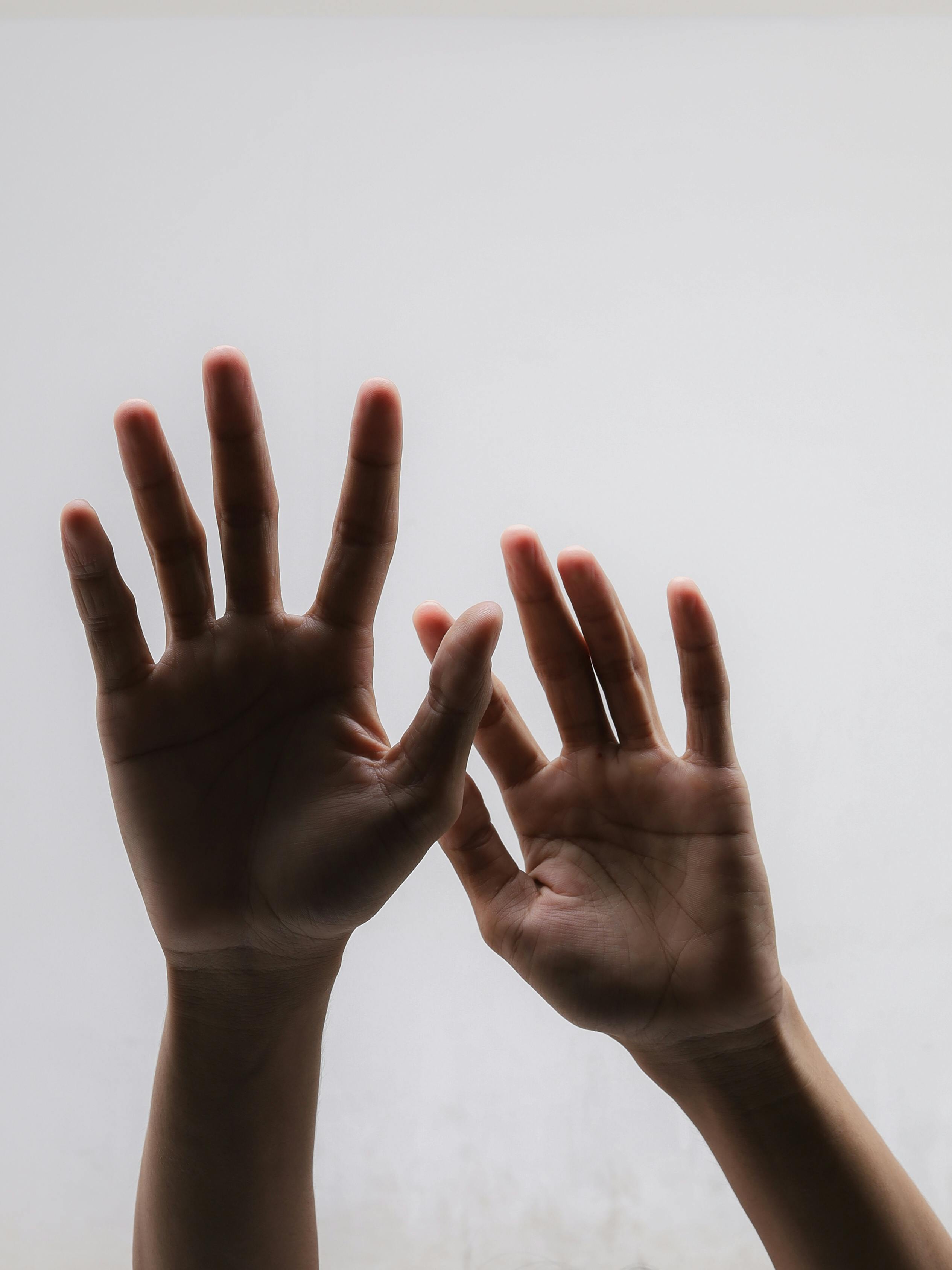 Безкоштовне Силует рук з розчепіреними пальцями на однотонному фоні передає елегантність та простоту. стокове фото