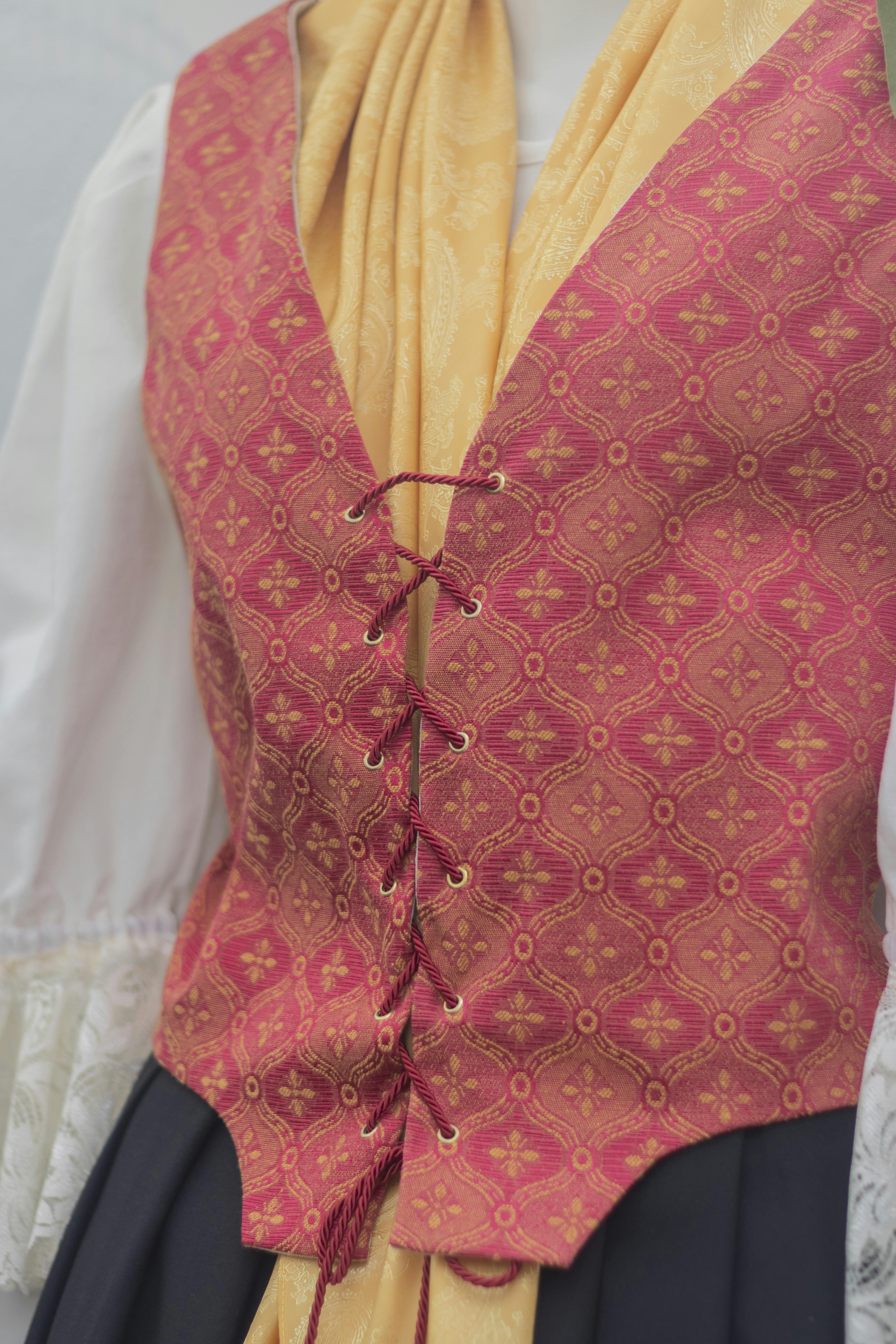 Gratis Primo piano di un tradizionale corsetto rosso e oro con decorazioni e dettagli di allacciatura. Foto a disposizione