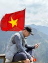 Man Relaxing with Smartphone by Vietnamese Flag
