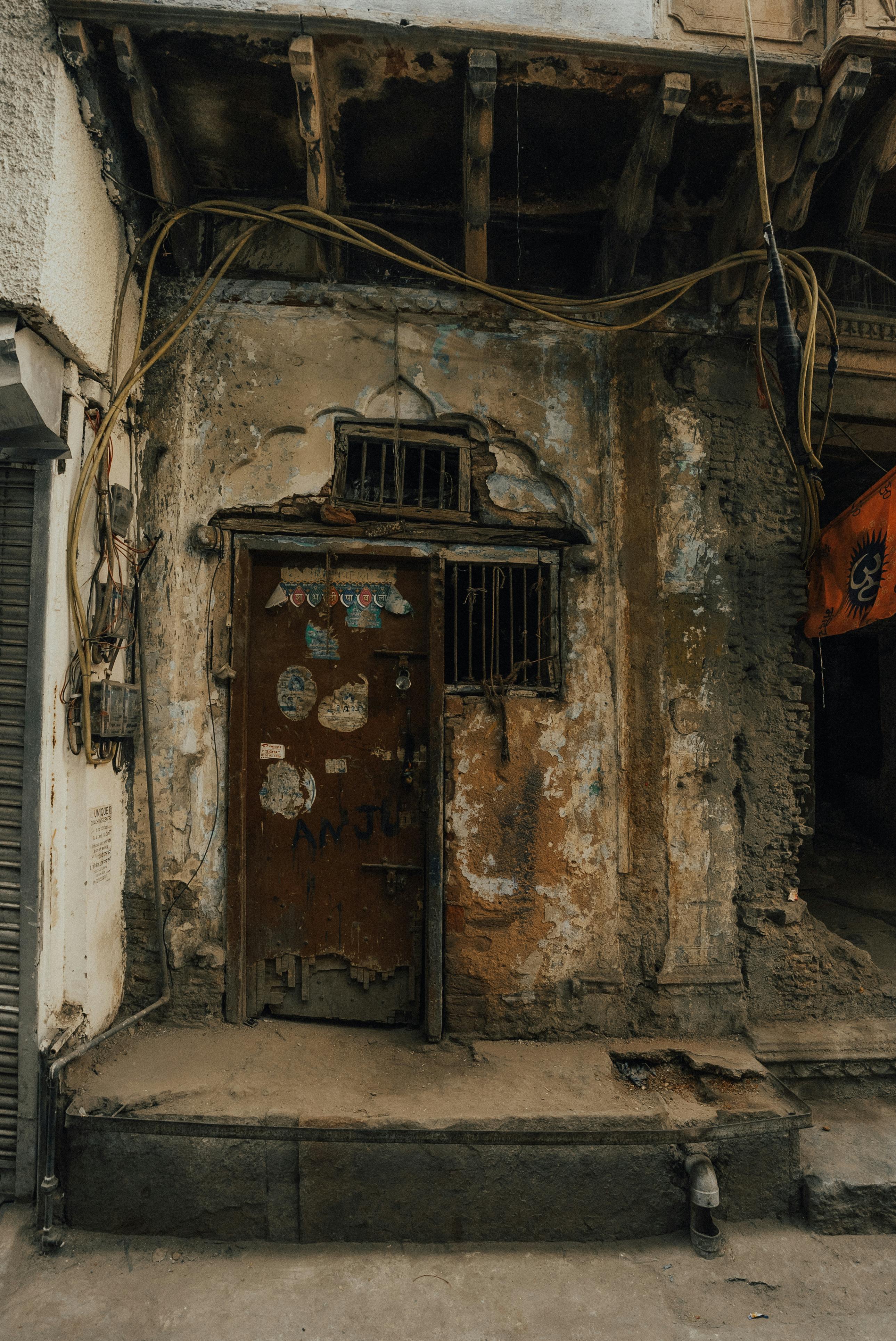 ฟรี ประตูไม้เก่าแก่ที่ผุพังในสภาพแวดล้อมเมืองที่ดูดิบๆ สีลอกล่อน และผนังทรุดโทรม คลังภาพถ่าย