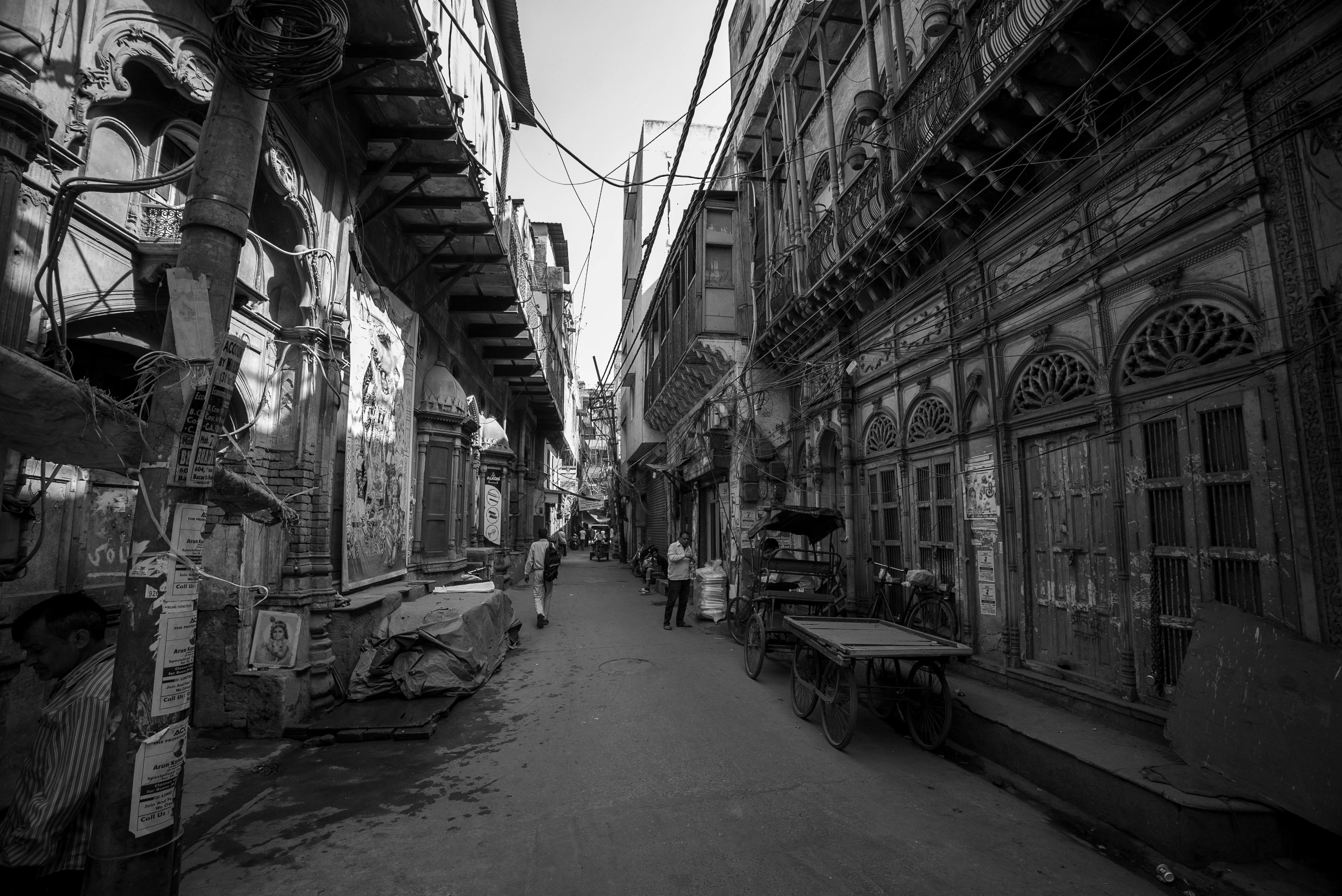 gratis Een smal, levendig steegje in zwart-wit legt historische architectuur en het bruisende straatleven vast. Stockfoto