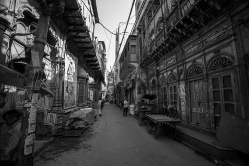 Free A narrow, bustling alleyway in black and white captures historic architecture and lively street life. Stock Photo