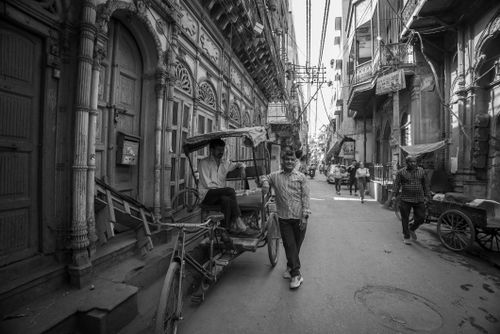 Free A bustling street captures daily life with a traditional rickshaw in black and white. Stock Photo