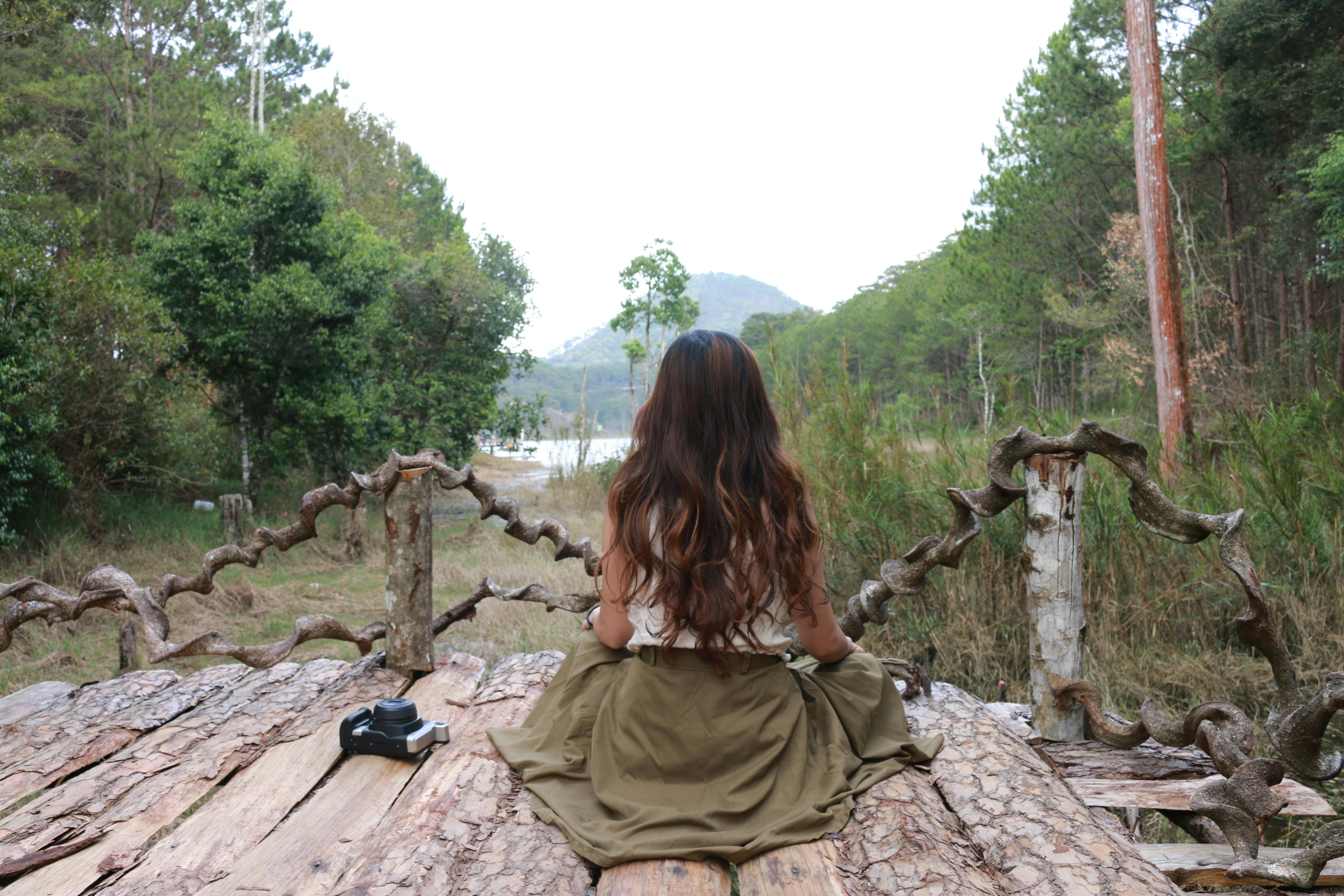 Zadarmo Žena pokojne medituje na rustikálnom drevenom moste v bujnom borovicovom lese. Fotka z fotobanky