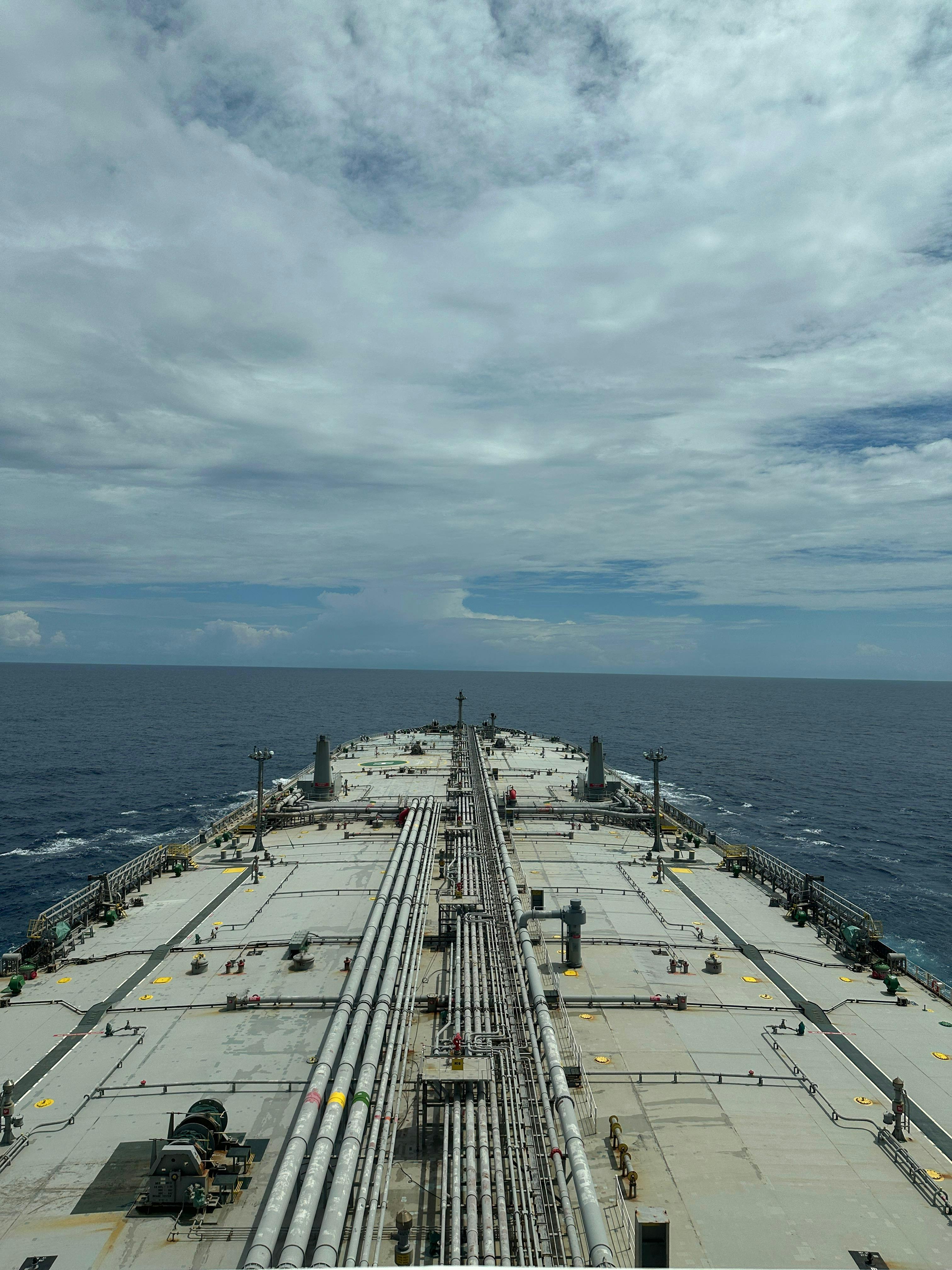 無料 曇り空の下、広大な貨物船の甲板が外洋へと伸びている。 写真素材