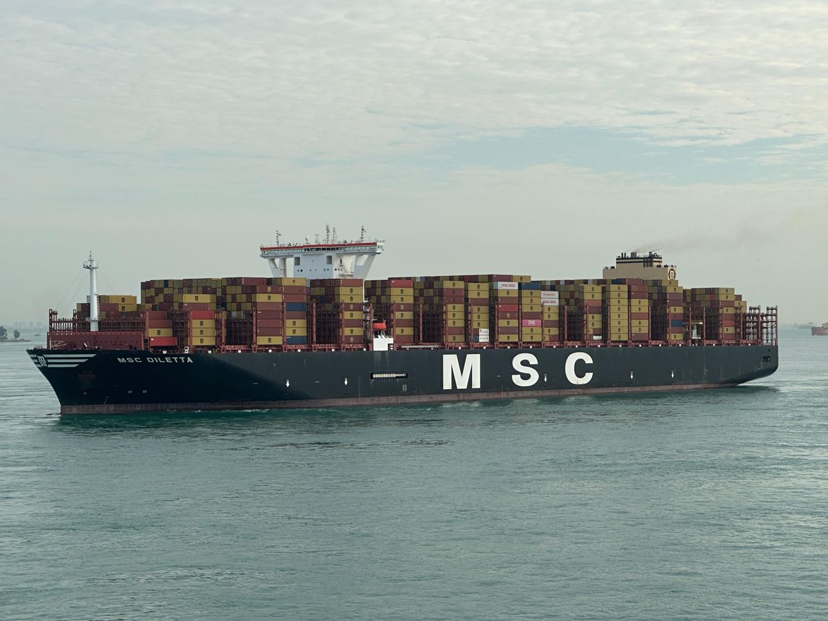 Cargo ship with stacked containers navigating open waters
