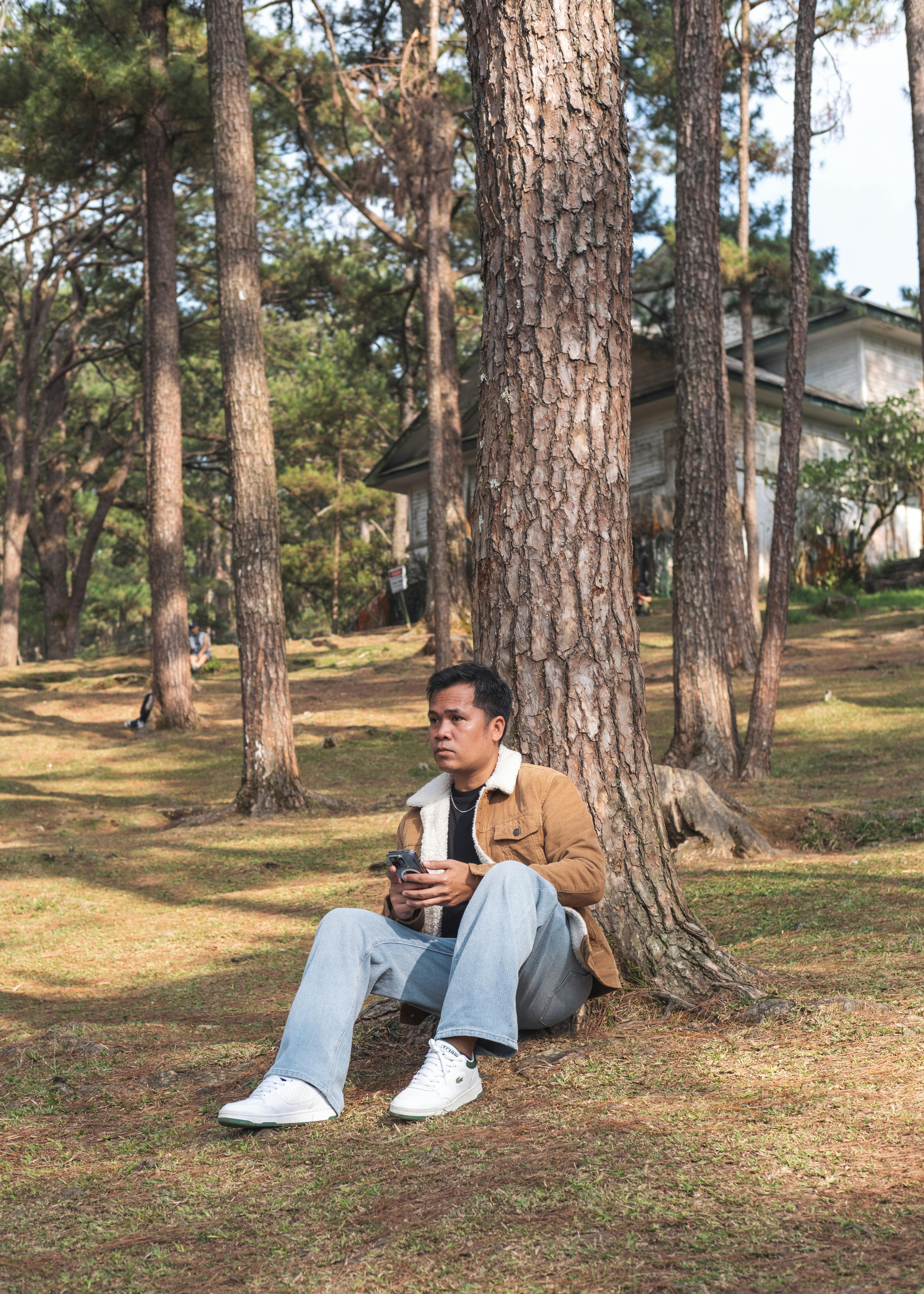 gratis Een man geniet van een rustige koffiepauze in een zonnig bos. Stockfoto