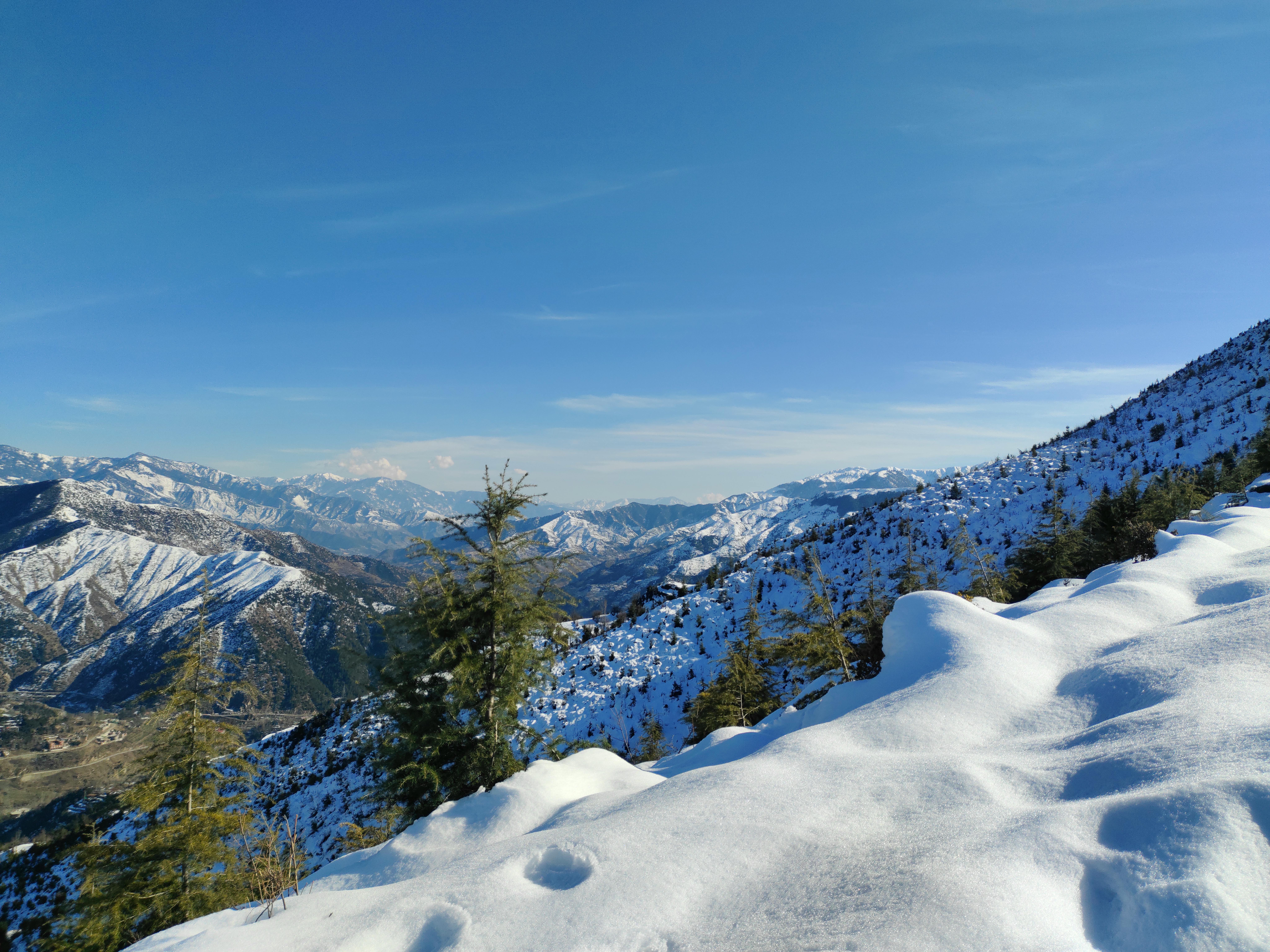 Kostenlos Ein atemberaubender Blick auf schneebedeckte Berge unter klarem, blauem Himmel – perfekt als Inspiration für Winterreisen. Stock-Foto