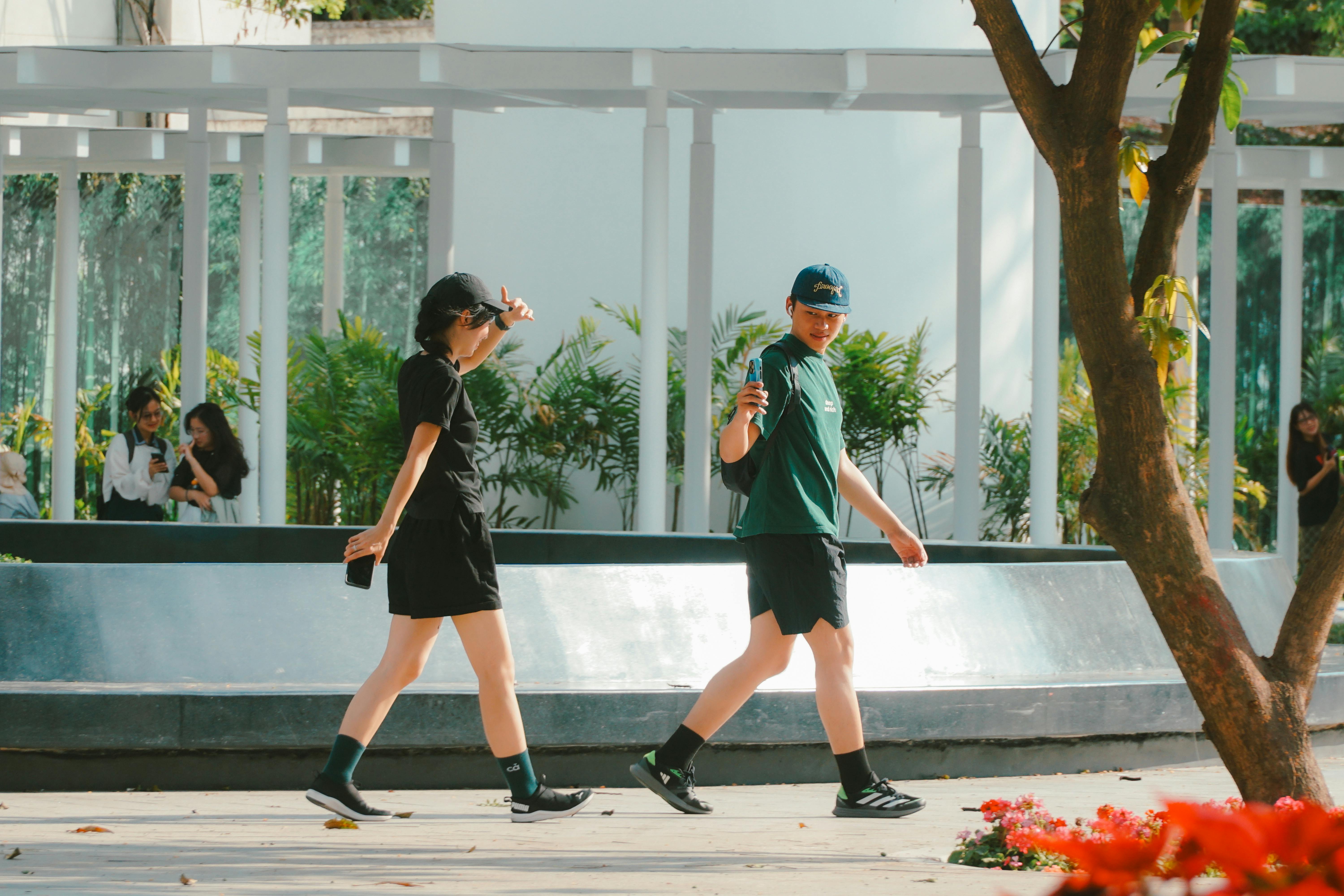 무료 베트남 호치민시의 한 공원에서 사람들이 화창한 날을 즐기며 산책하고 있다. 스톡 사진