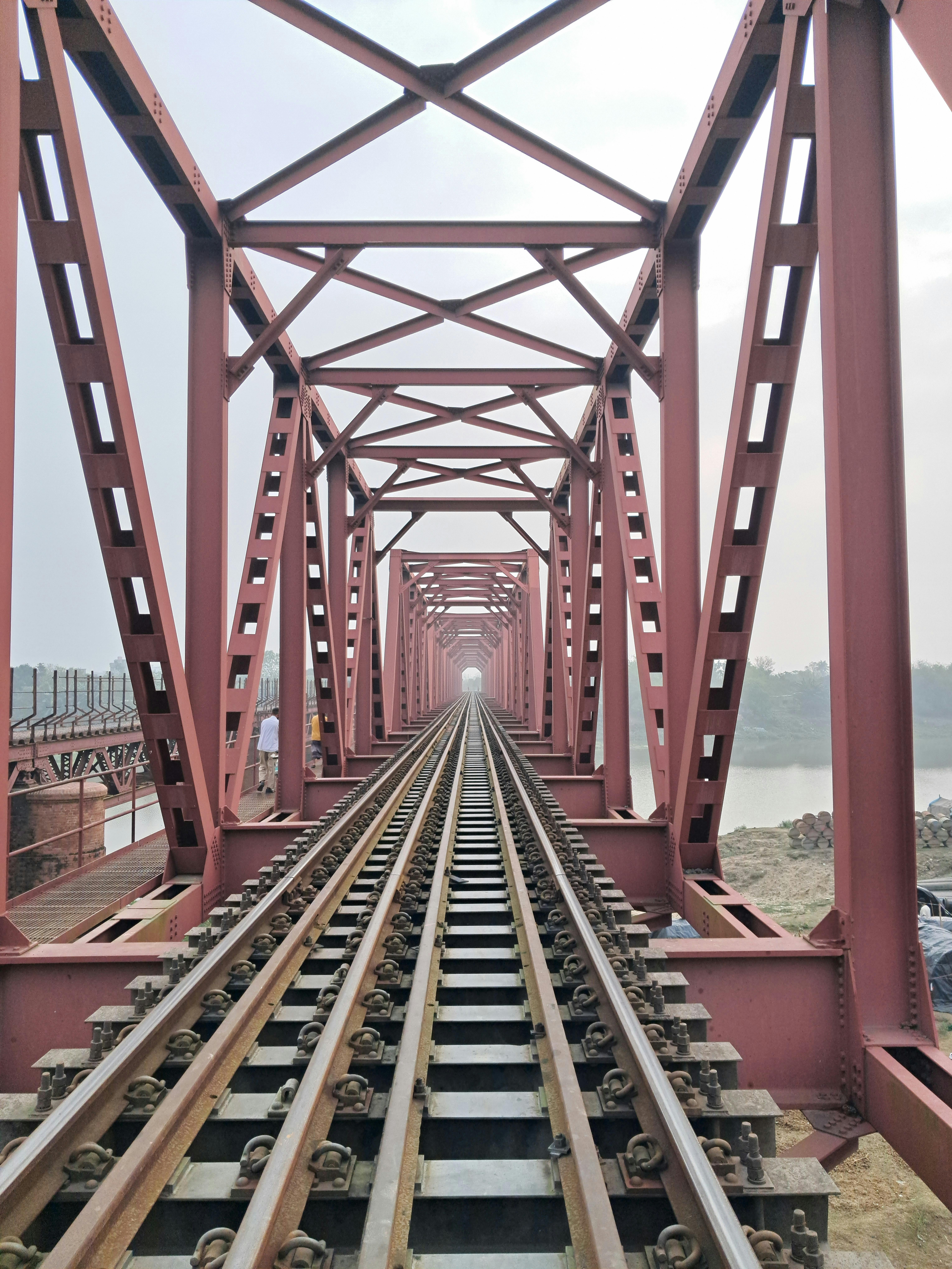 免費 一座紅色鋼結構鐵路橋的引人注目的視角，展現了工業設計和工程線條。 圖庫相片