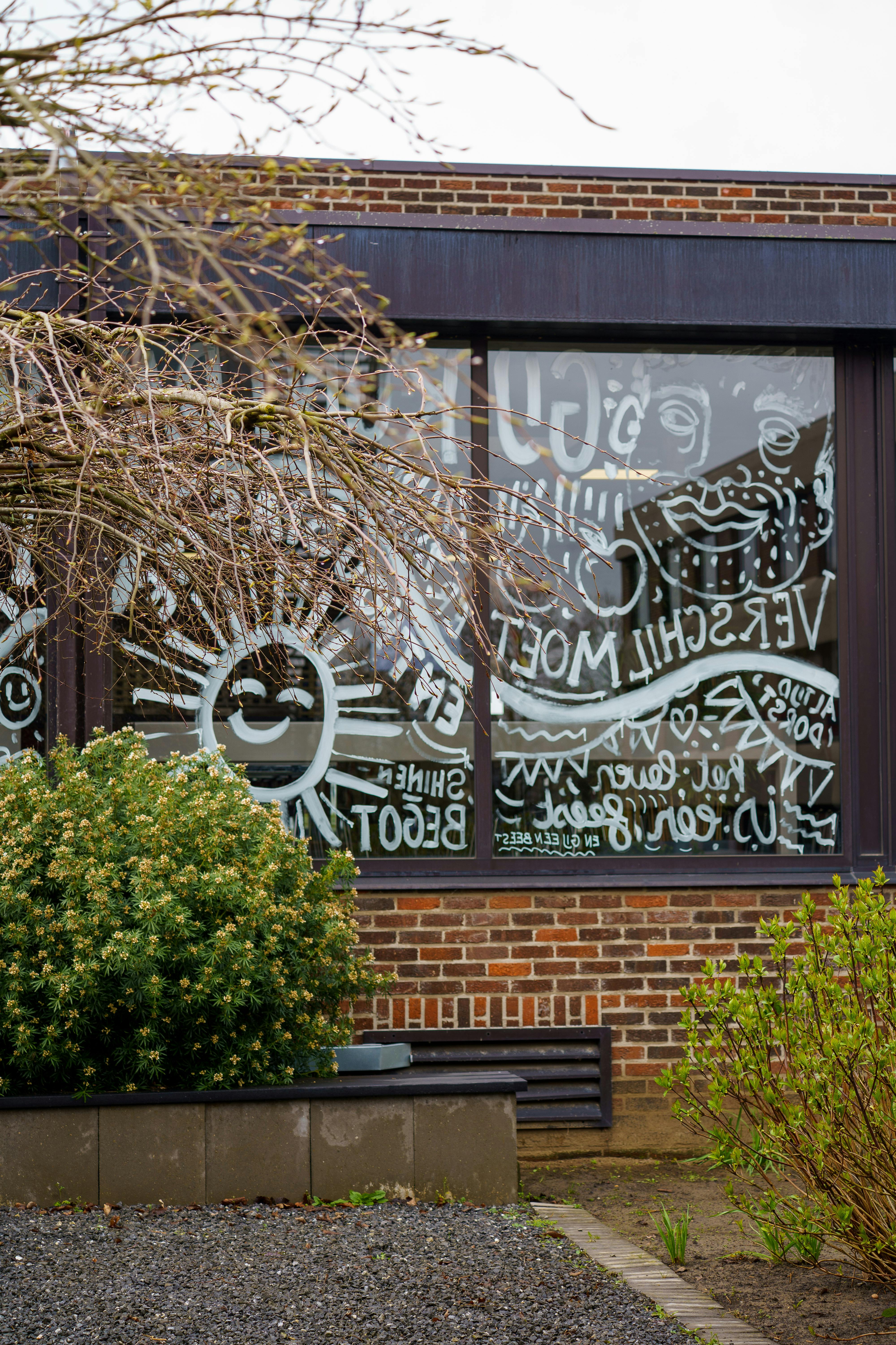 Gratuit Décoration murale colorée représentant du soleil et des motifs abstraits sur une vitrine d'un immeuble à Geel, en Belgique. Photos