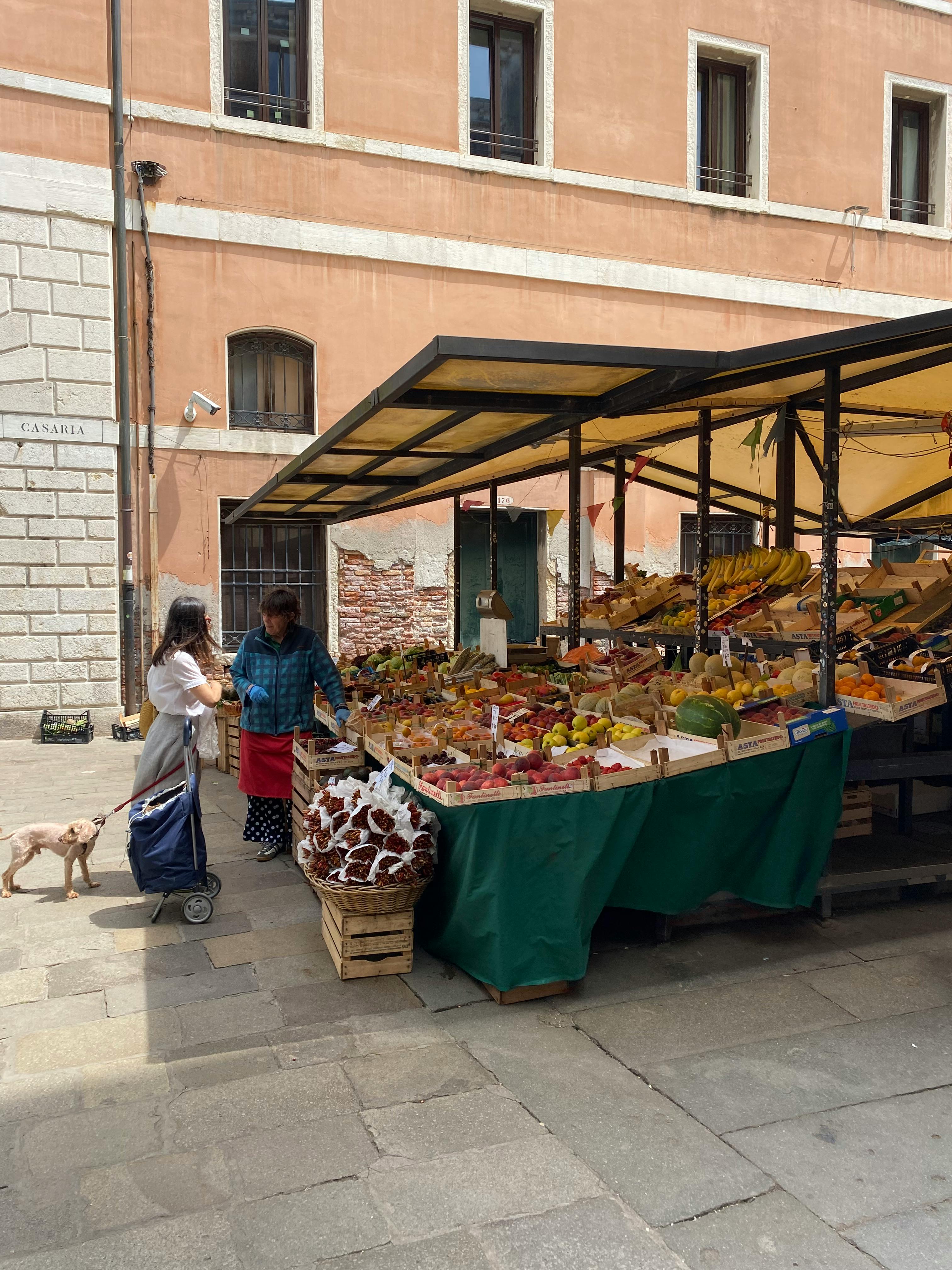Gratis Et livligt udendørs marked med friske råvarer og folk, der handler under en solrig himmel. Lagerfoto