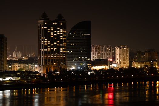 Stunning nighttime view of Hangzhou's illuminated skyline reflecting on the river.
