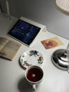 Cozy Desk Setup with Tea and Tablet Streaming Music